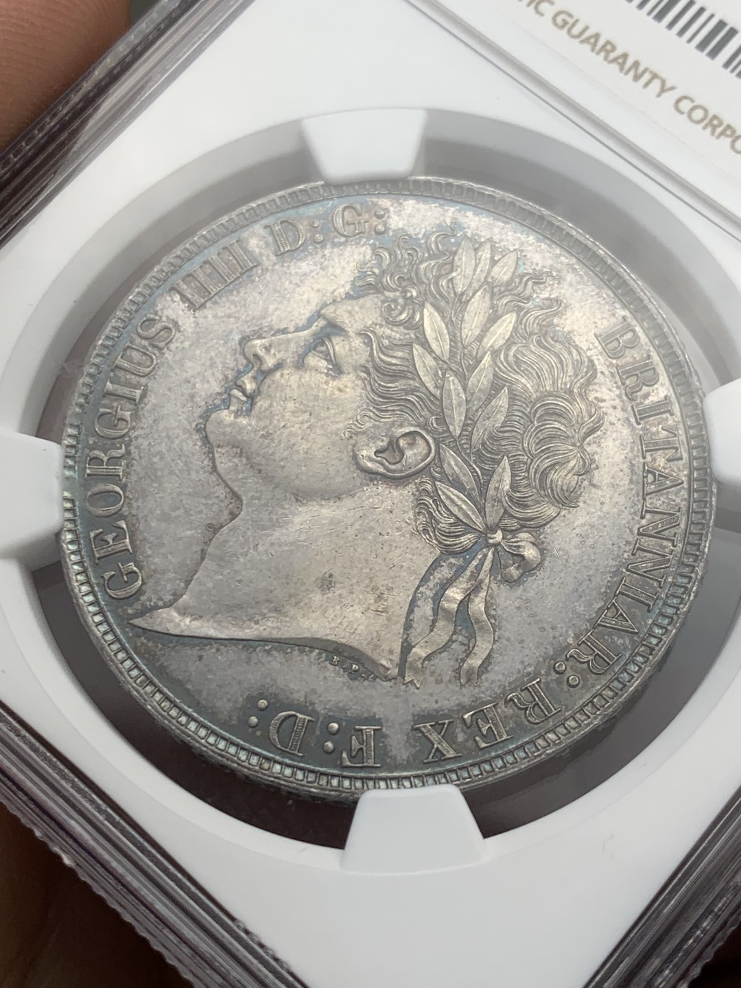 欢迎参加《竞宝斋》五一特拍-第161场-周日，周一 2场 NGC MS62 英国 1821年 乔治四世马剑克朗 好彩低评 发丝完美 马剑面无可挑剔 实物孔雀蓝彩