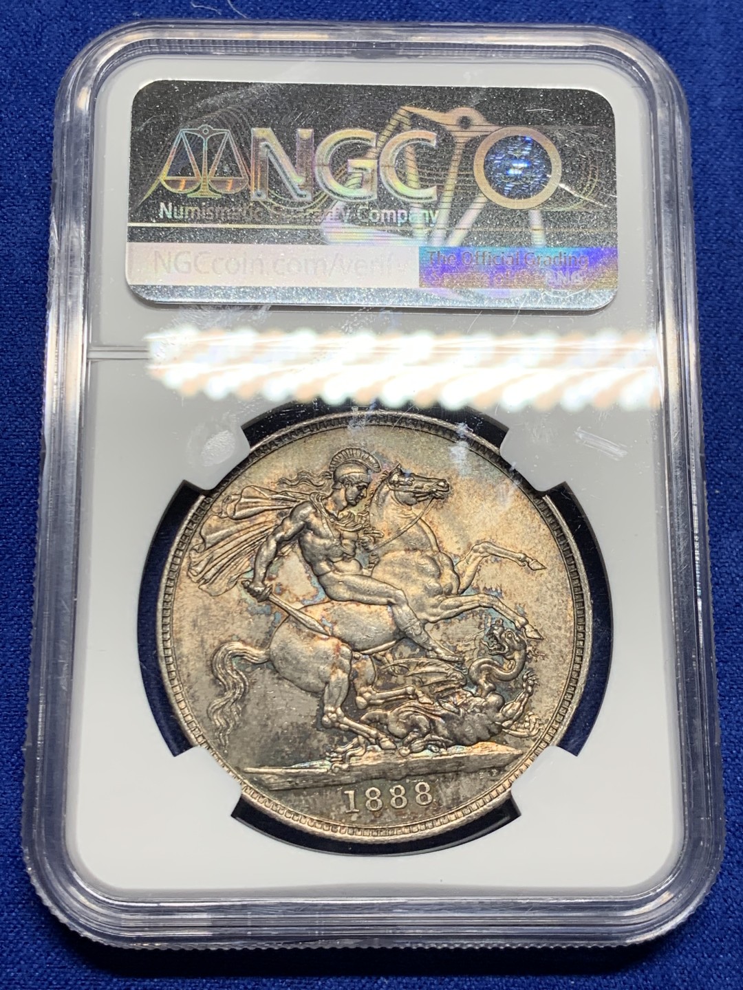 欢迎参加《竞宝斋》五一特拍-第161场-周日，周一 2场 NGC-MS62 英国1888年 1克朗 马剑银币，五彩包浆，盒子略有划痕，不影响密封 稀缺MS