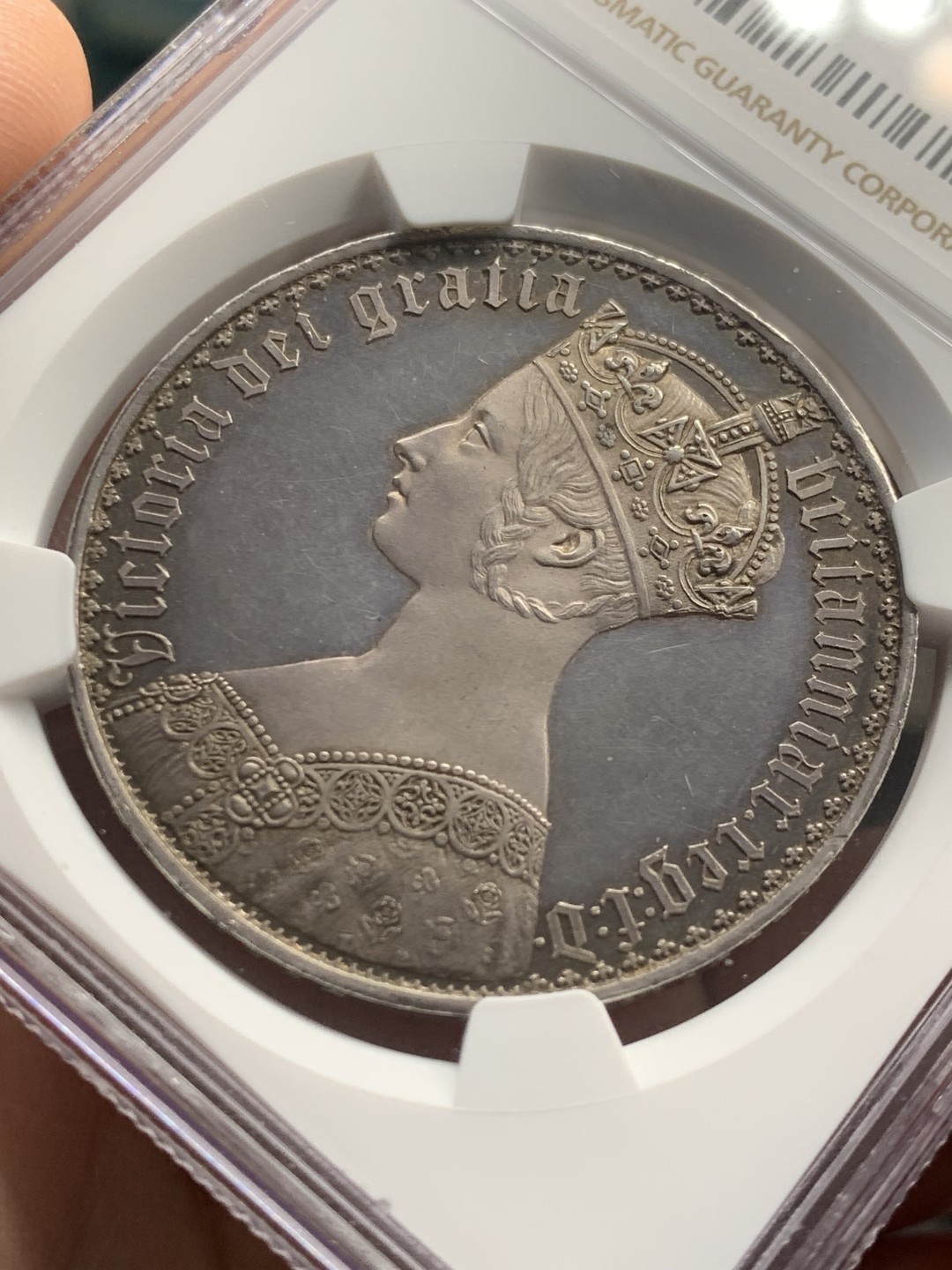 欢迎参加《竞宝斋》五一特拍-第161场-周日，周一 2场 NGC PF62CAMEO 英国 1847年 哥特克朗 大名誉品 带cam的很少 该枚底板镜面效果明显 女王人像中心紫红彩 外围深蓝环彩 背面深蓝环彩 底板干净清爽 无明显拉丝 综合非常棒的一枚哥特克朗