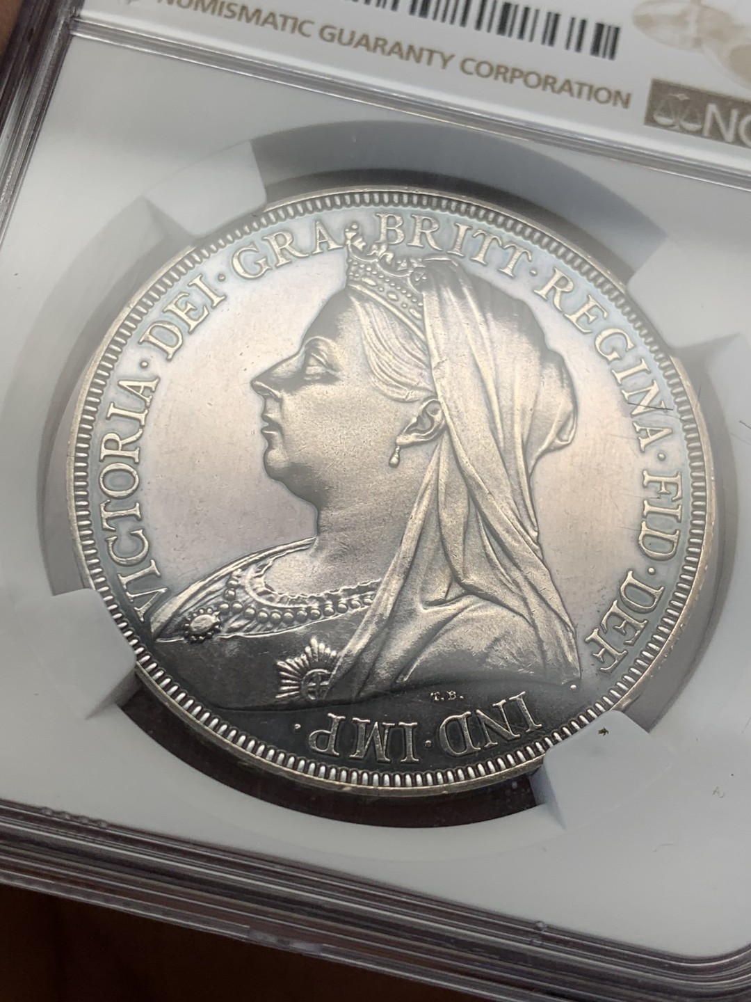 欢迎参加《竞宝斋》五一特拍-第161场-周日，周一 2场 NGC PF63 英国 1893年 精制披纱克朗 女王面冷峻哥特风灰彩 整体很搭阿尔伯特亲王去世后 女王披纱悼念的场景 马剑面深蓝满彩 真正的BULE BLOOD 收藏级精制马剑