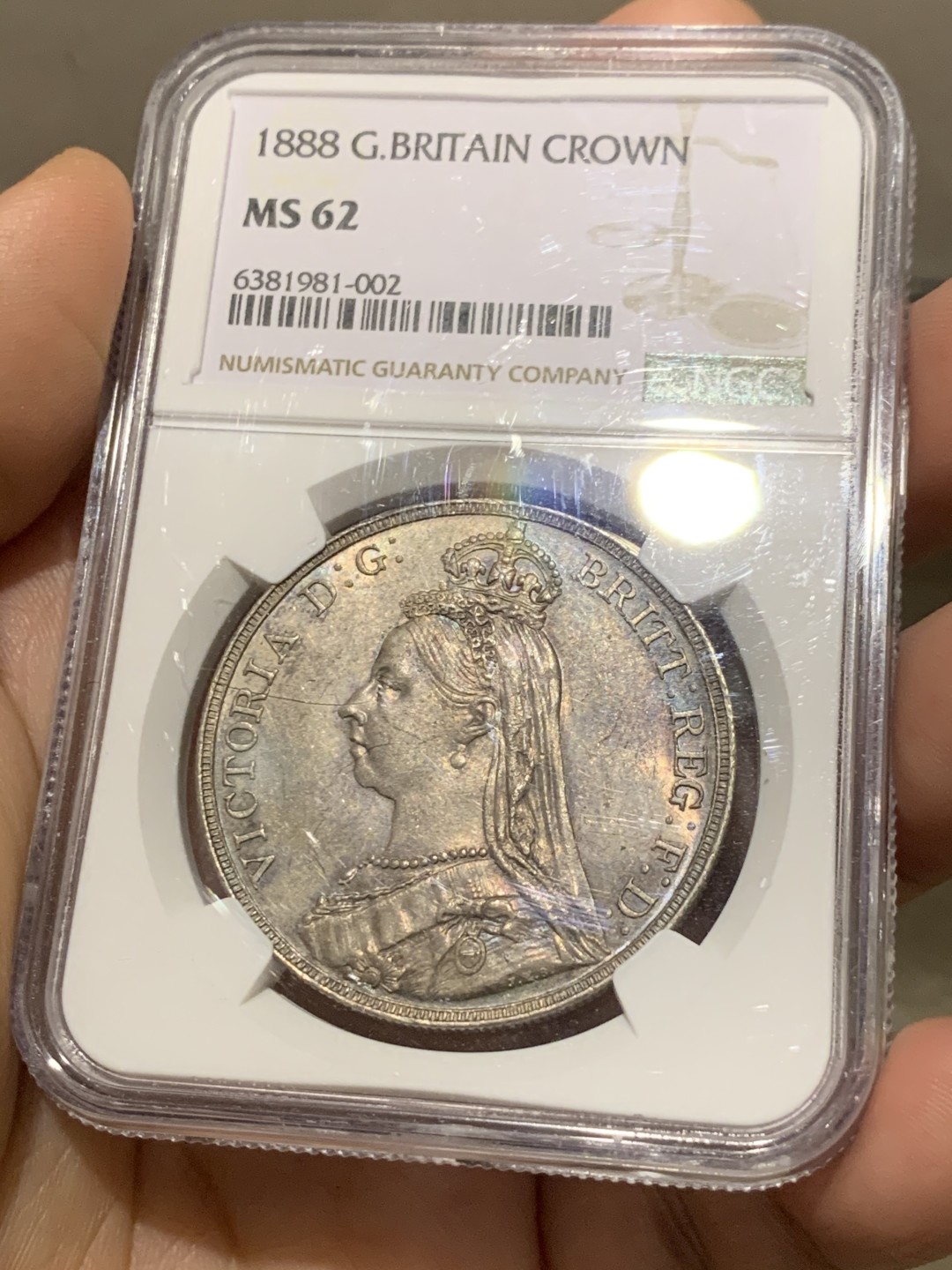 欢迎参加《竞宝斋》五一特拍-第161场-周日，周一 2场 NGC-MS62 英国1888年 1克朗 马剑银币，五彩包浆，盒子略有划痕，不影响密封 稀缺MS