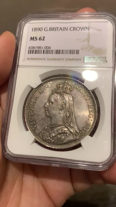 欢迎参加《竞宝斋》五一特拍-第161场-周日，周一 2场 NGC-MS62 英国1890年 1克朗 马剑银币，环彩包浆，较少见年份