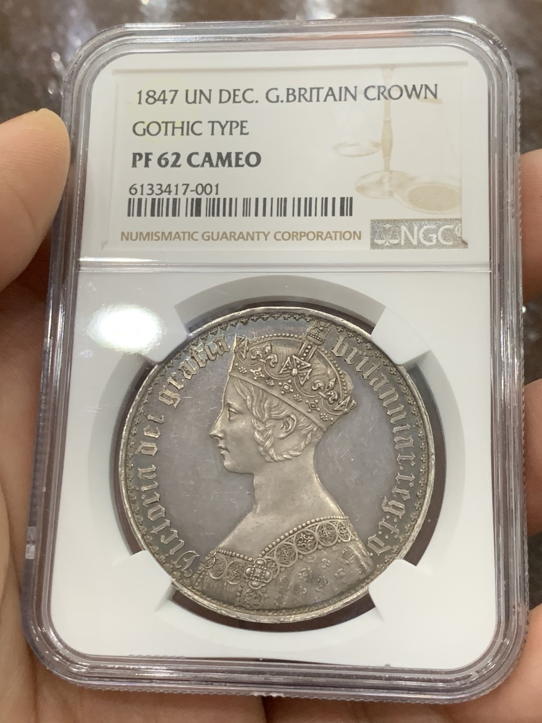 欢迎参加《竞宝斋》五一特拍-第161场-周日，周一 2场 NGC PF62CAMEO 英国 1847年 哥特克朗 大名誉品 带cam的很少 该枚底板镜面效果明显 女王人像中心紫红彩 外围深蓝环彩 背面深蓝环彩 底板干净清爽 无明显拉丝 综合非常棒的一枚哥特克朗