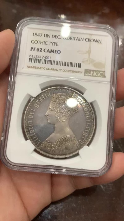 欢迎参加《竞宝斋》五一特拍-第161场-周日，周一 2场 NGC PF62CAMEO 英国 1847年 哥特克朗 大名誉品 带cam的很少 该枚底板镜面效果明显 女王人像中心紫红彩 外围深蓝环彩 背面深蓝环彩 底板干净清爽 无明显拉丝 综合非常棒的一枚哥特克朗