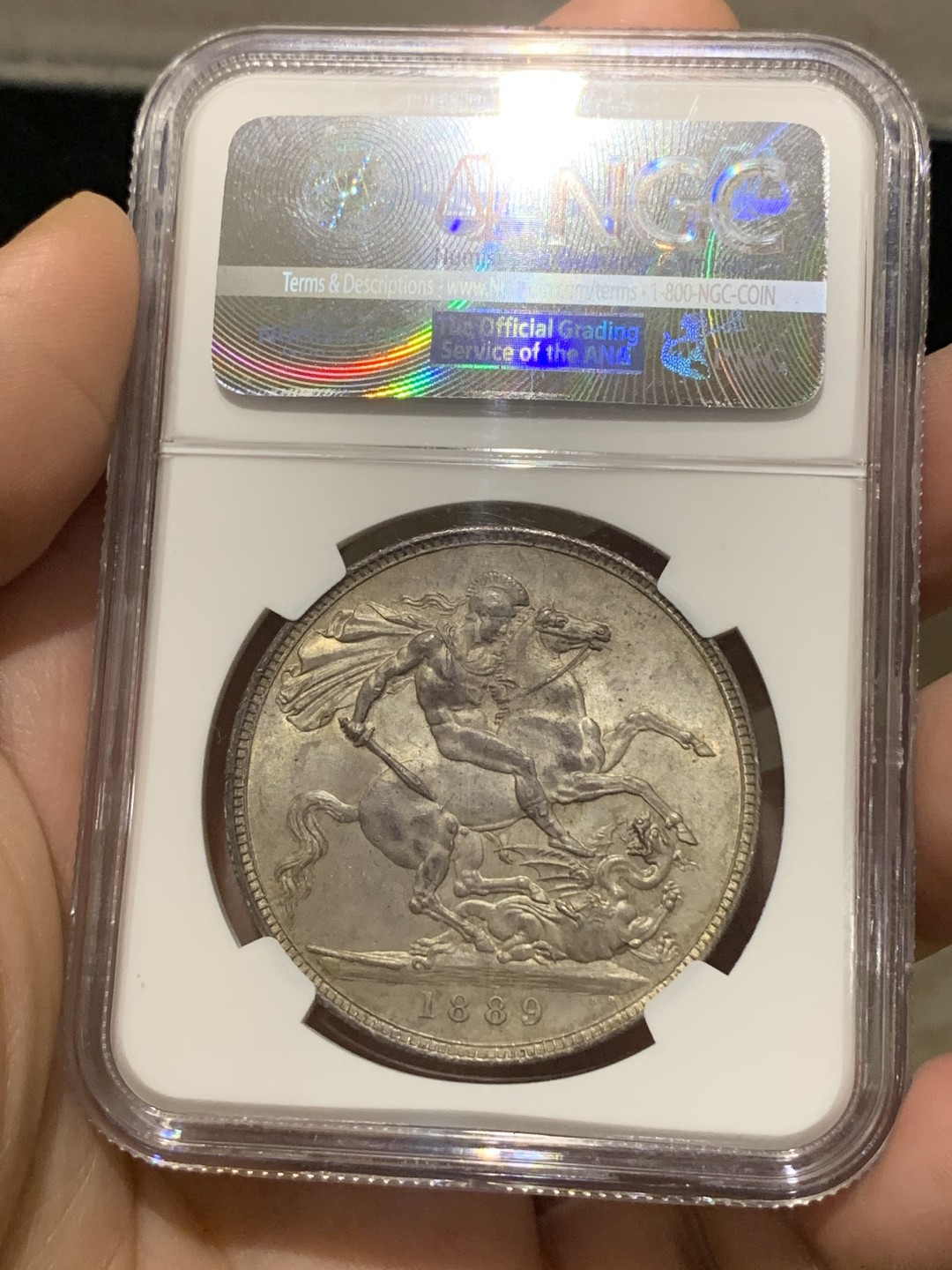 欢迎参加《竞宝斋》五一特拍-第161场-周日，周一 2场 NGC-MS63 英国1889年 维多利亚 高冠版 马剑 克朗大银币 包浆浑厚