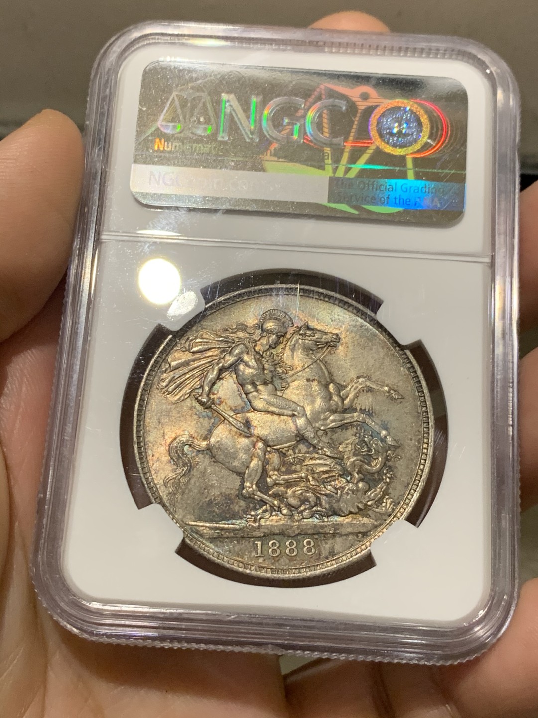 欢迎参加《竞宝斋》五一特拍-第161场-周日，周一 2场 NGC-MS62 英国1888年 1克朗 马剑银币，五彩包浆，盒子略有划痕，不影响密封 稀缺MS