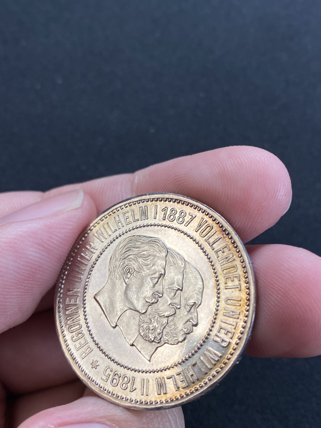 万国钱币拍卖第008期（慕尼黑2T之夜） 1895年德国基尔运河三皇银章，镜面浮雕，边缘略有磕碰，淡紫彩，PCGS原评UNCD，砸盒裸章。