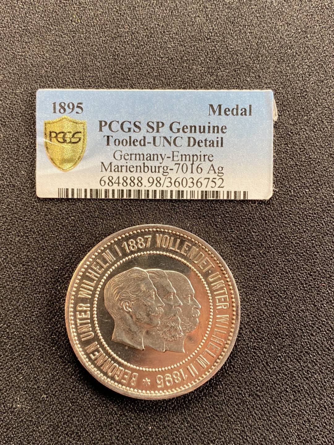万国钱币拍卖第008期（慕尼黑2T之夜） 1895年德国基尔运河三皇银章，镜面浮雕，边缘略有磕碰，淡紫彩，PCGS原评UNCD，砸盒裸章。