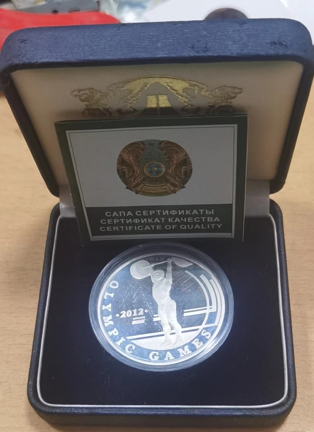 北京马甸外国币专卖微拍第九十七期，外国金银币专场，陆续上新，欢迎关注 哈萨克斯坦2010年100元精制纪念1盎司银币（第三十届伦敦运动会举重），成色：925，盒证齐全 