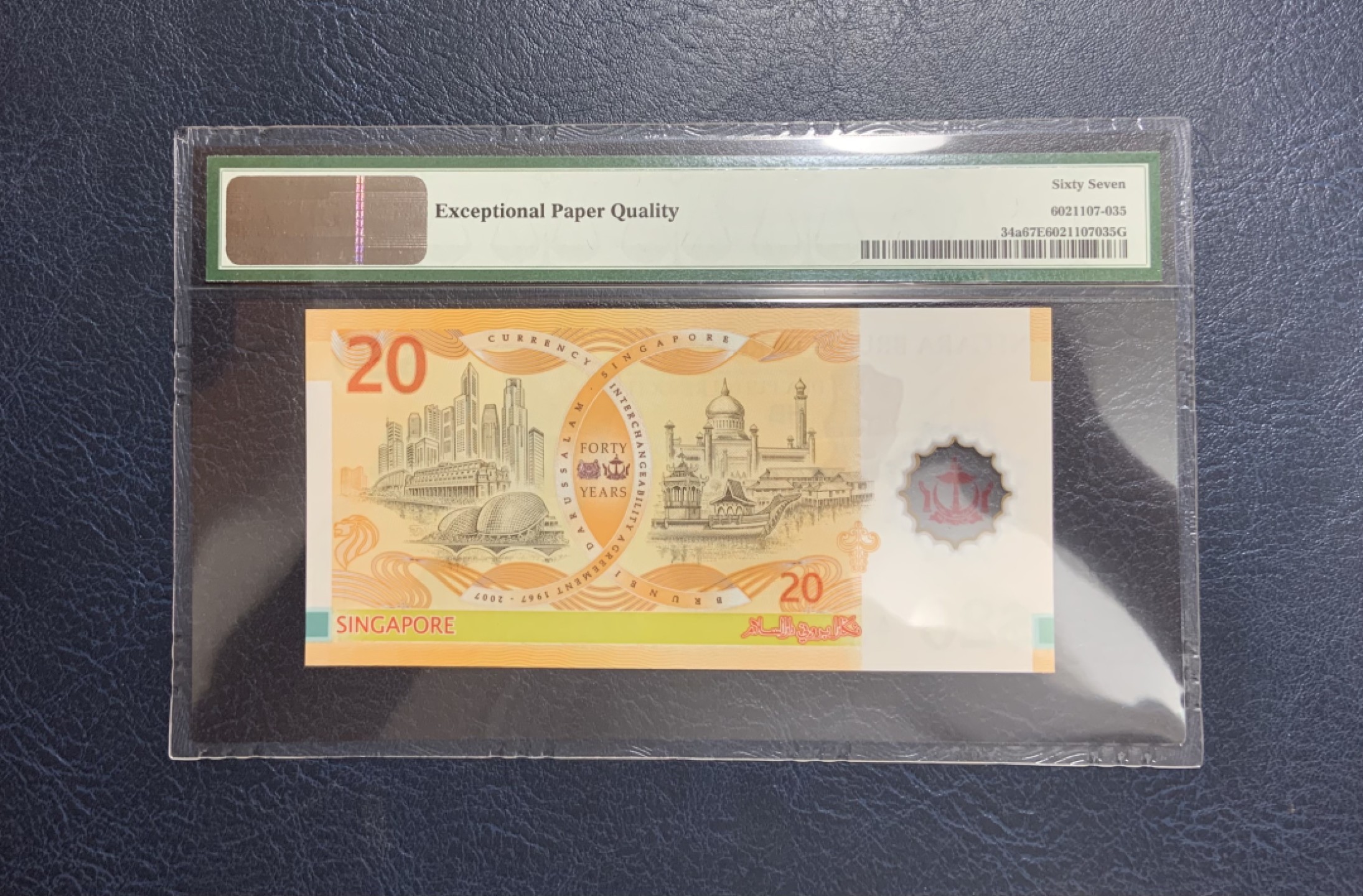 收藏联盟Quantum Auction 第261期拍卖  文莱2007年20吉令特货币等值40周年纪念钞 PMG67 首发A/1 号码无47