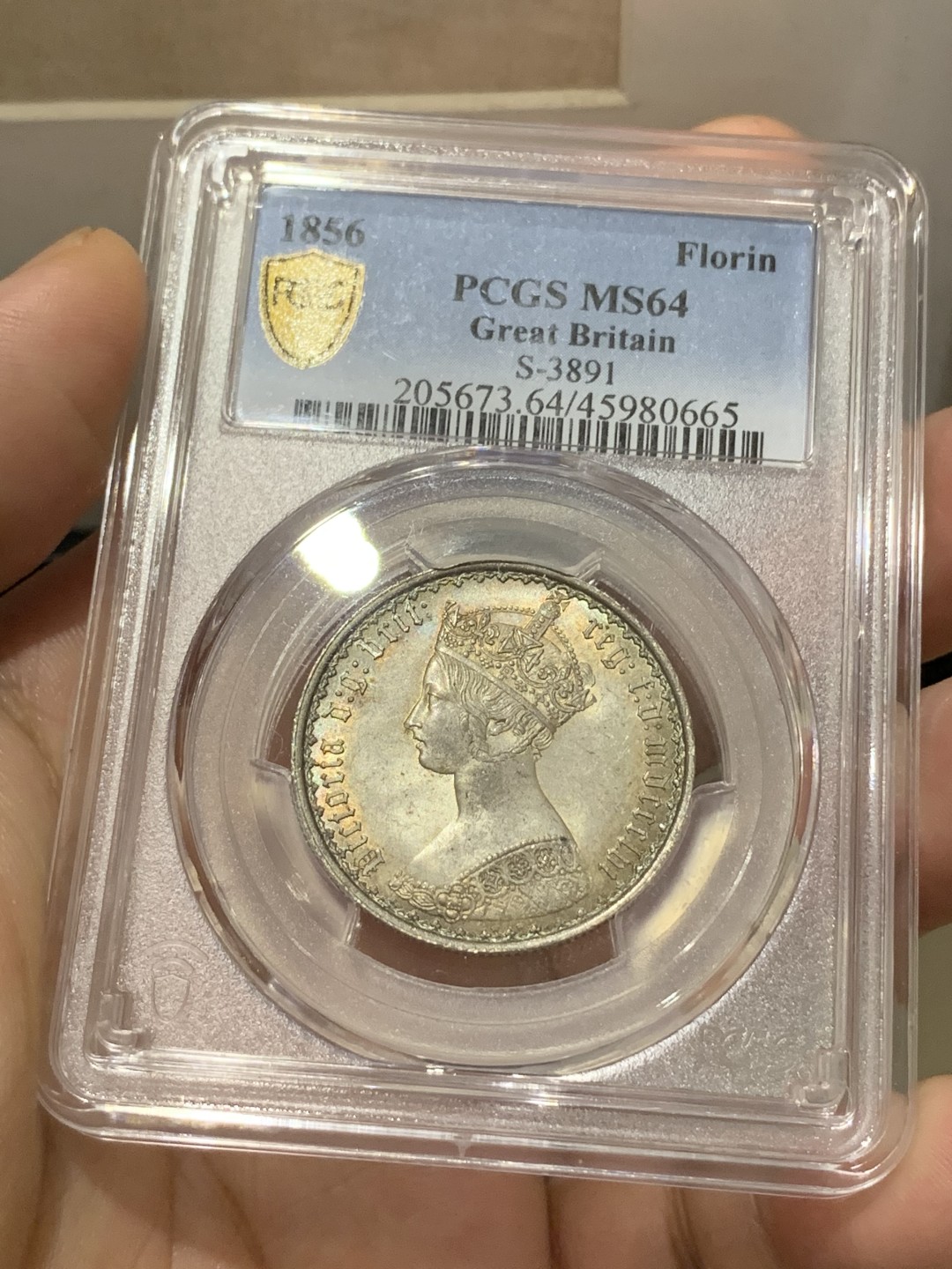 《竞宝斋》第169场-周日，周一2场 (全场包邮) PCGS MS64 英国1856年哥特弗洛林银币，较为稀少的早期年份，双面五彩包浆，狮子的脸都打的很清晰，整体状态非常好的一枚