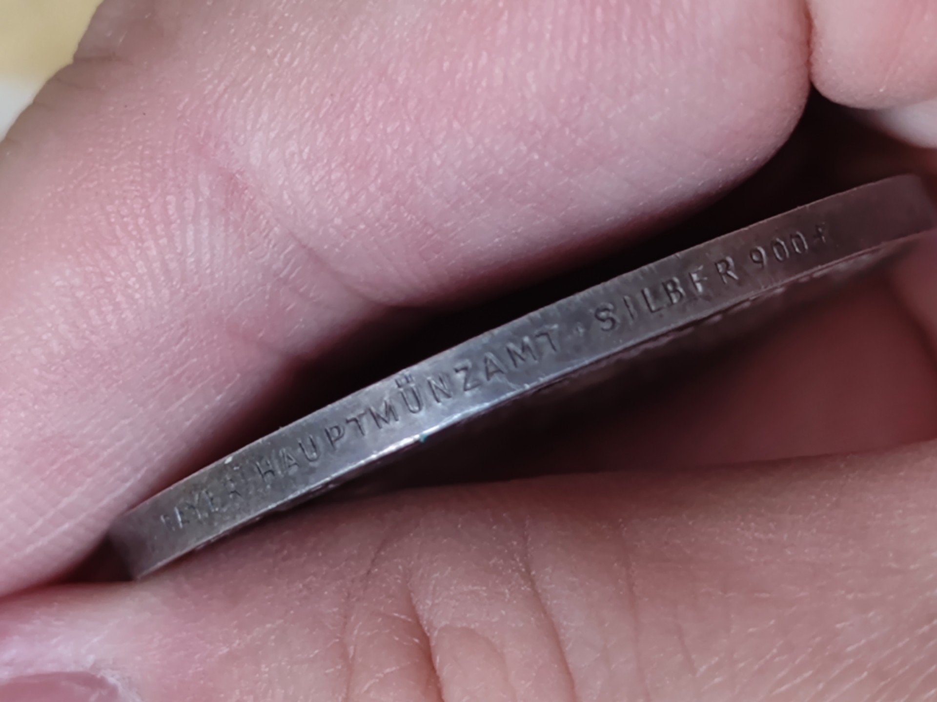 世界精品徽章拍卖~第五场 1933年的德三银制纪念币，正面是一个人像，边铭Bayer Haupmuenzamt Silber 900+（巴伐利亚硬币总局 900银）