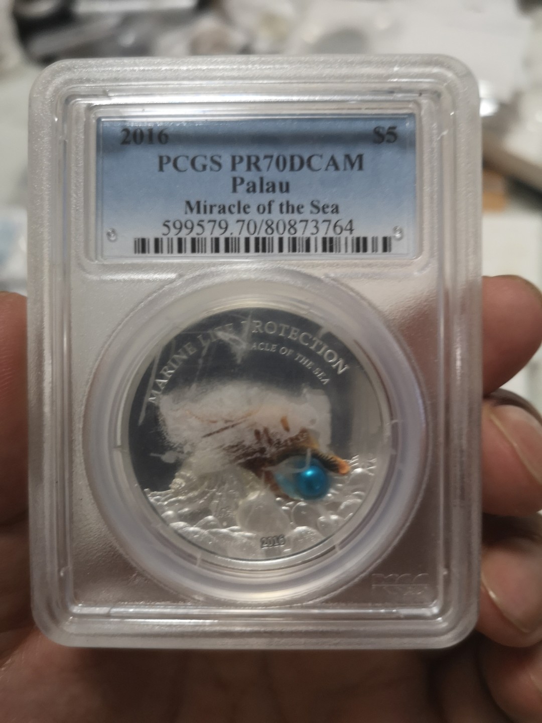 长老汇第4场现代币拍卖 帕劳2016珍珠镶嵌精制银币，PCGS PR70DCAM，评级币盒上有胶带印痕
