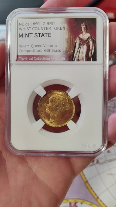 橡树集藏-006场 海纳百川 约1850年 英国 维多利亚女王 惠斯特牌代用币，在牌局中充当计数工具。尺寸参考了索维林的22mm，表面镀金，视觉效果和金镑无二，且少见的出厂状态，工艺比那些汉诺威的token要好上许多许多，雕刻技艺亦可圈可点，亚克力盒为开放式