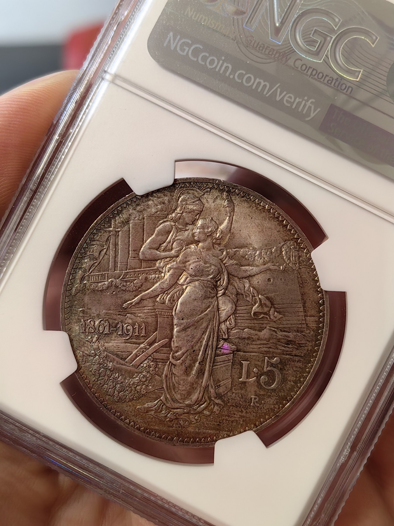 橡树集藏-006场 海纳百川 ngc-ms64 1911年意大利建国5里拉大银币 打制优异 浮雕完好 整体状态相当不错 币圈大托奶  罗马厂内部评选最美设计 正面为埃马努埃莱三世，意大利国王。背面图案为代表古罗马的士兵和代表现代意大利的女神，以及象征工农业繁荣的轮船、犁铧和花环。背面情景指的是古罗马向现代罗马——意大利递送地球，象征治世权力的传承～币的边铭，刻有双环八字结，代表爱的意思，萨伏伊王室常用。