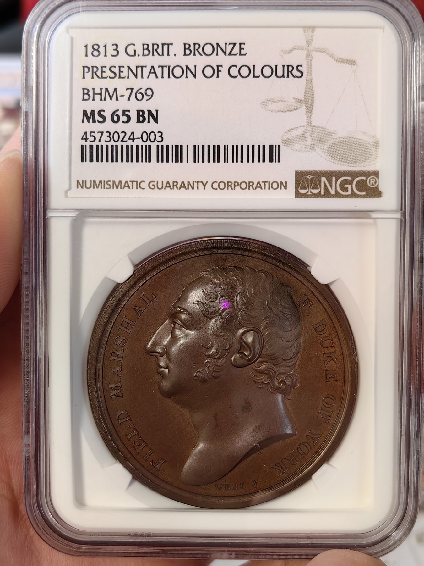 橡树集藏-006场 海纳百川 1813年英国皇室章，乔治三世时期原铸。ngc Ms65，加厚盒。铜色诱人，镜面感十足。背面是女王向皇家近卫军团授予军旗，细节丰富，雕刻精细，超高浮雕。ngc数据库唯一评级，冠军分。军旗上刻字：VIRES ACQUIRT EUNDO。拉丁文，意为“随行聚力”，是古罗马诗人的叙事诗《埃涅阿斯纪》中的一句，意思是“随着传播而越来越有力”。象征着军队听从指挥，雷厉风行。