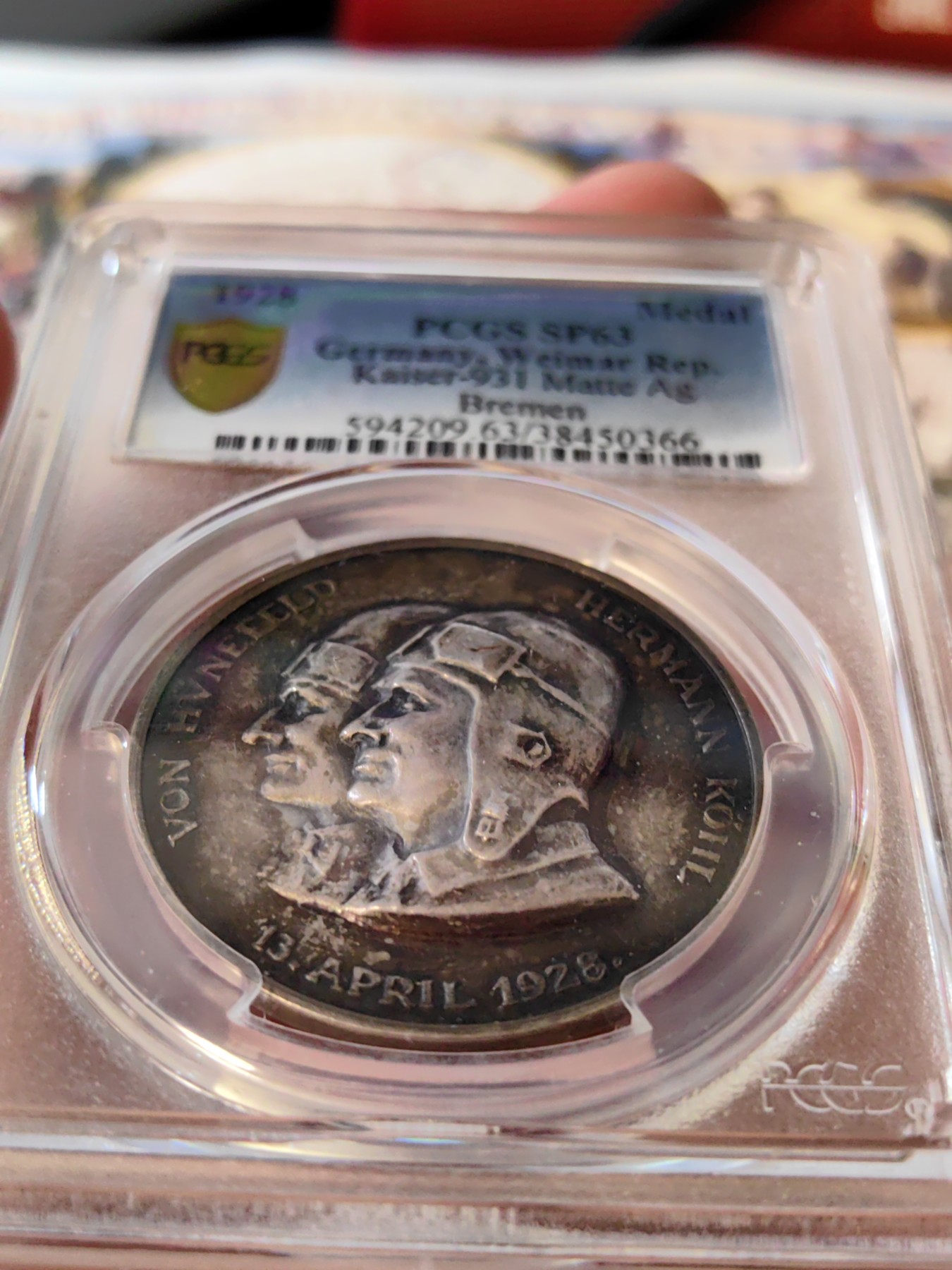 橡树集藏-006场 海纳百川 1928年德国银章，pcgs SP63。纪念不莱梅号飞机飞越大西洋。1928年4月13日，两名德国飞行员驾驶飞机在美国费城着陆，这是人类首次驾驶飞机从大西洋东岸飞到西岸。这两名飞行员在费城受到了盛大欢迎，德国人也以他们为傲，发行 多枚以此事件为主题的纪念章。 双面浓郁包浆，五彩，超高浮雕，实物极美。 人物刻画精细，背面的不莱梅号穿过云雾，飞翔在大西洋上空，海面波光粼粼，惟妙惟肖。