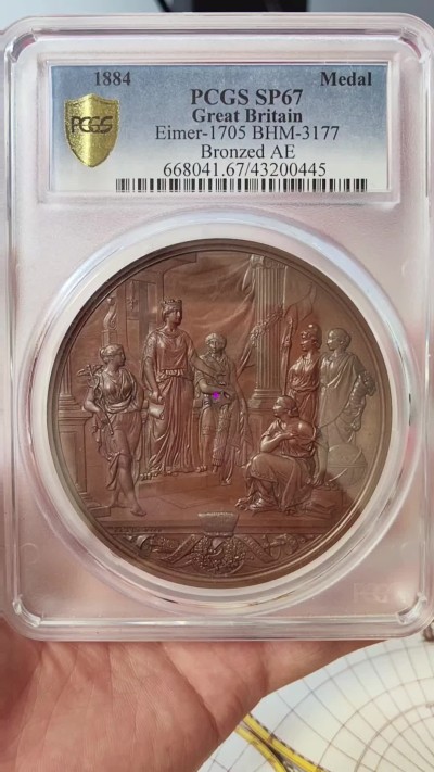 橡树集藏-006场 海纳百川 pcgs-sp67！ 1884年英国伦敦金融城系列 大不列颠市政厅铜牌新议会厅开幕，伦敦造币厂。作者：JS & AB Wyon。直径：77毫米。正面：伦迪尼亚，商业和治安法官出席，向她的议会发表讲话；背面：市政厅内景。这种高度复杂的反向设计显示出令人难以置信的雄伟，是任何大教堂和建筑相关奖牌的高级收藏者的必备品。丰富的红棕色表面，具有巨大的光泽度，令人叹为观止。附带原盒，插销损坏。