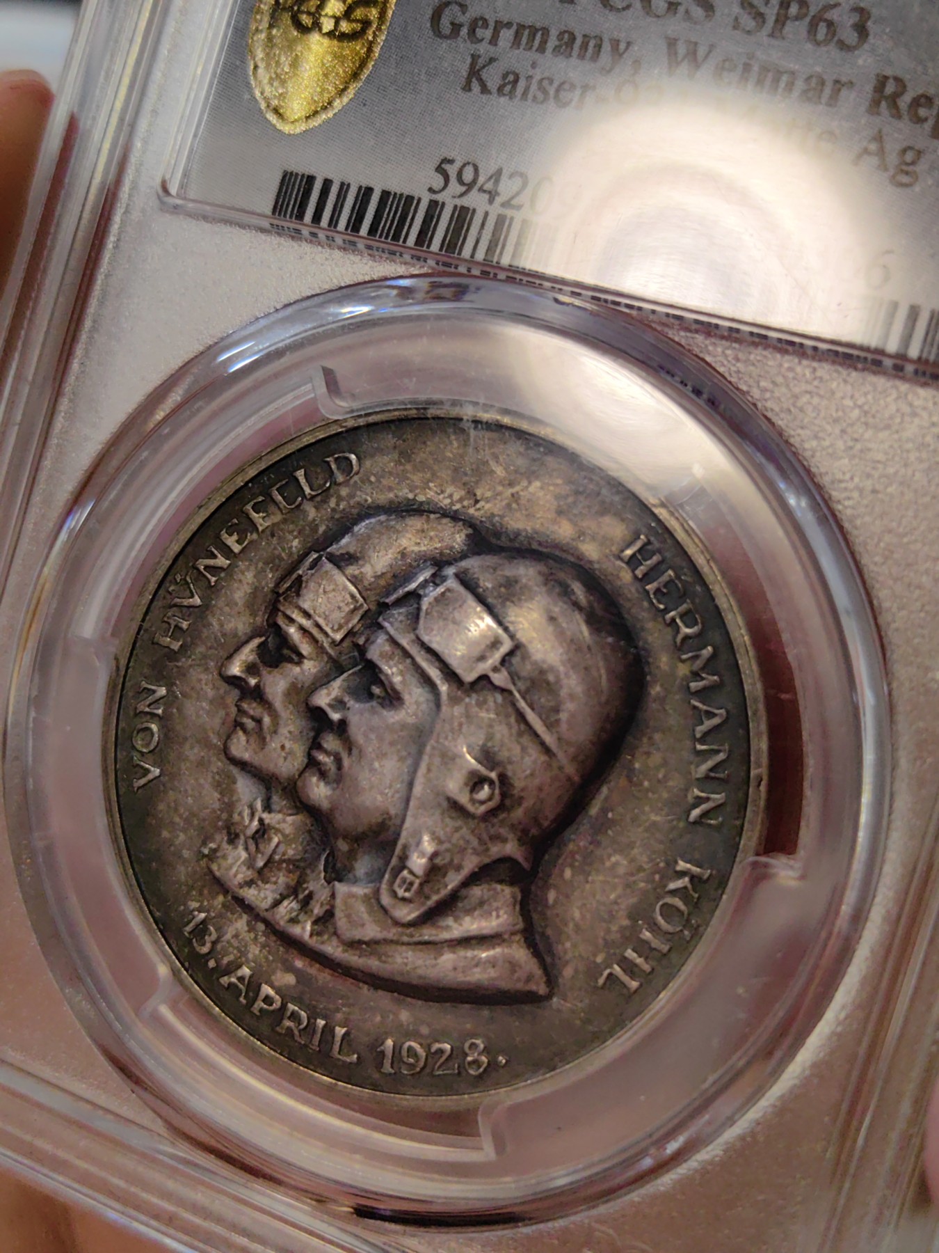 橡树集藏-006场 海纳百川 1928年德国银章，pcgs SP63。纪念不莱梅号飞机飞越大西洋。1928年4月13日，两名德国飞行员驾驶飞机在美国费城着陆，这是人类首次驾驶飞机从大西洋东岸飞到西岸。这两名飞行员在费城受到了盛大欢迎，德国人也以他们为傲，发行 多枚以此事件为主题的纪念章。 双面浓郁包浆，五彩，超高浮雕，实物极美。 人物刻画精细，背面的不莱梅号穿过云雾，飞翔在大西洋上空，海面波光粼粼，惟妙惟肖。