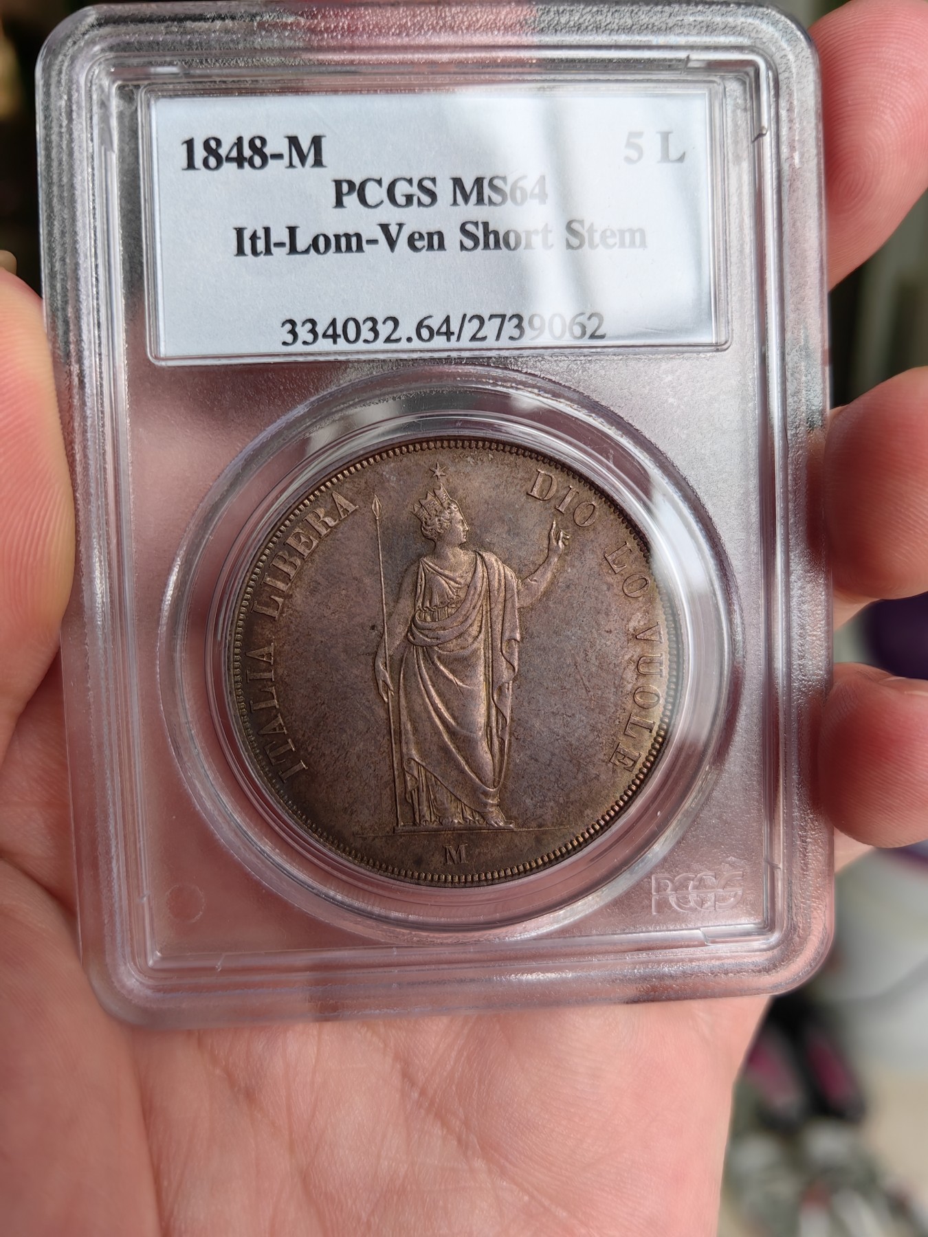 橡树集藏-006场 海纳百川 PCGS MS-64  1848年意大利伦巴第-威尼斯5里拉大银，米兰造币厂。钢灰色的底板呈现出琥珀色和浅洋红色虹彩的痕迹，突出了整个币面。背面有罕见的包浆回声纹，底板几乎没有瑕疵。pc老盒子，品质保证。正面是右手执长矛权杖的加冕自由女神，拉丁铭文:ITALIA LIBERA DIO LO VUOLE，上帝呼唤自由之意大利。女神的左手指向铭文“DIO”,意大利语中上帝的意思，很有深意的经典设计。 