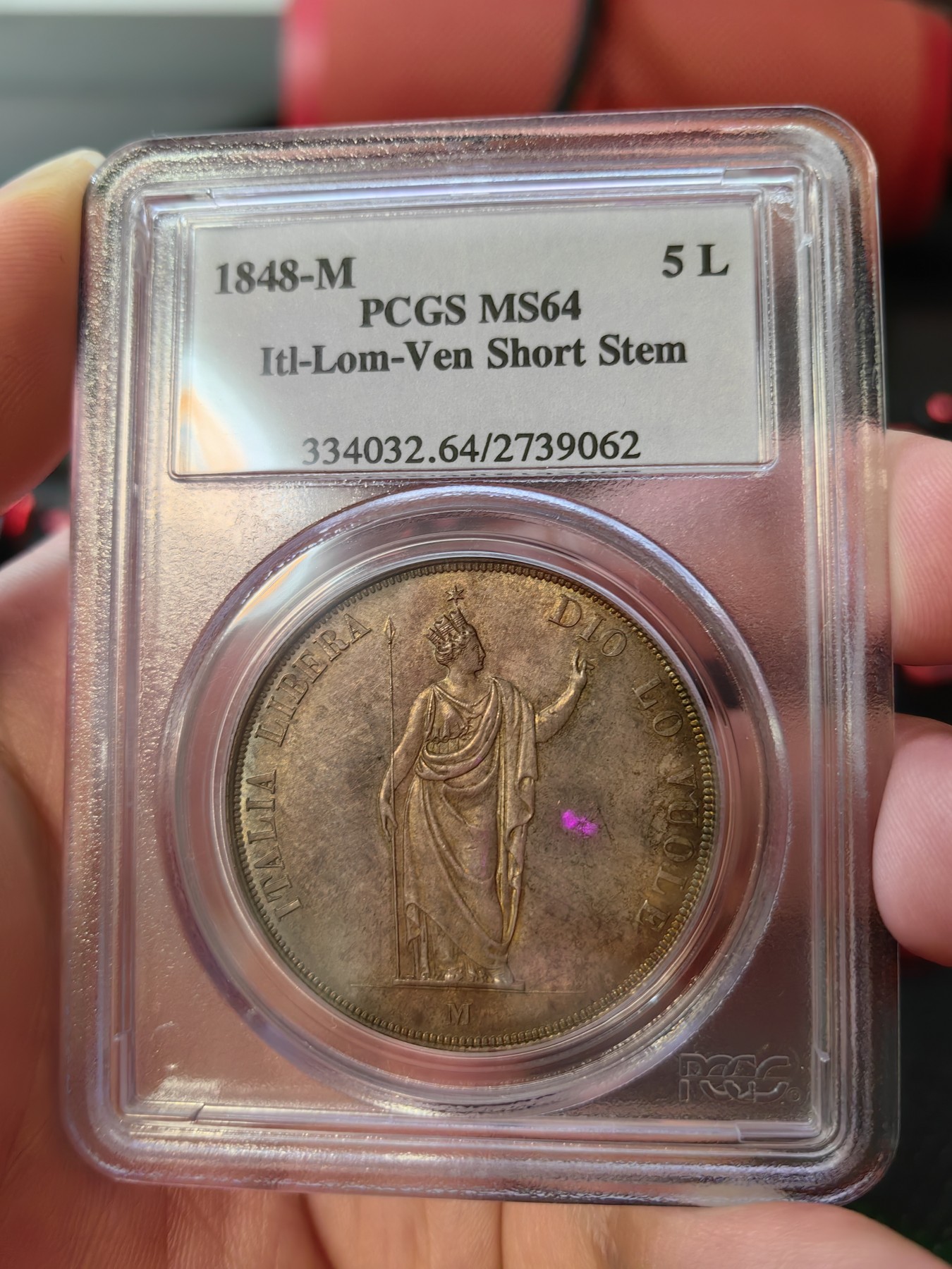 橡树集藏-006场 海纳百川 PCGS MS-64  1848年意大利伦巴第-威尼斯5里拉大银，米兰造币厂。钢灰色的底板呈现出琥珀色和浅洋红色虹彩的痕迹，突出了整个币面。背面有罕见的包浆回声纹，底板几乎没有瑕疵。pc老盒子，品质保证。正面是右手执长矛权杖的加冕自由女神，拉丁铭文:ITALIA LIBERA DIO LO VUOLE，上帝呼唤自由之意大利。女神的左手指向铭文“DIO”,意大利语中上帝的意思，很有深意的经典设计。 