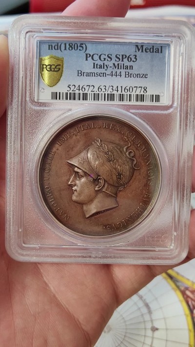 橡树集藏-006场 海纳百川 1805年法国拿破仑一世铜样章，pcgs-SP63。意大利米兰版本。数据库唯一亚军分，少见。攻占维也纳，原铸铜样章，42mm。超高浮雕加厚盒子，状态极佳，实物极美。正面:拿皇头戴月桂冠和柯林斯式头盔装饰有鹰和霹雳，冠饰蛇。背面:奥地利维也纳女神因首都被法军攻占，神情哀伤，有一种征服的快感。法兰西帝国拿破仑大帝的辉煌岁月，横扫欧洲。Vive La France！