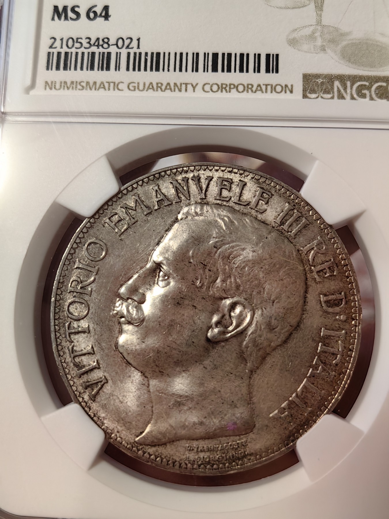 橡树集藏-006场 海纳百川 ngc-ms64 1911年意大利建国5里拉大银币 打制优异 浮雕完好 整体状态相当不错 币圈大托奶  罗马厂内部评选最美设计 正面为埃马努埃莱三世，意大利国王。背面图案为代表古罗马的士兵和代表现代意大利的女神，以及象征工农业繁荣的轮船、犁铧和花环。背面情景指的是古罗马向现代罗马——意大利递送地球，象征治世权力的传承～币的边铭，刻有双环八字结，代表爱的意思，萨伏伊王室常用。