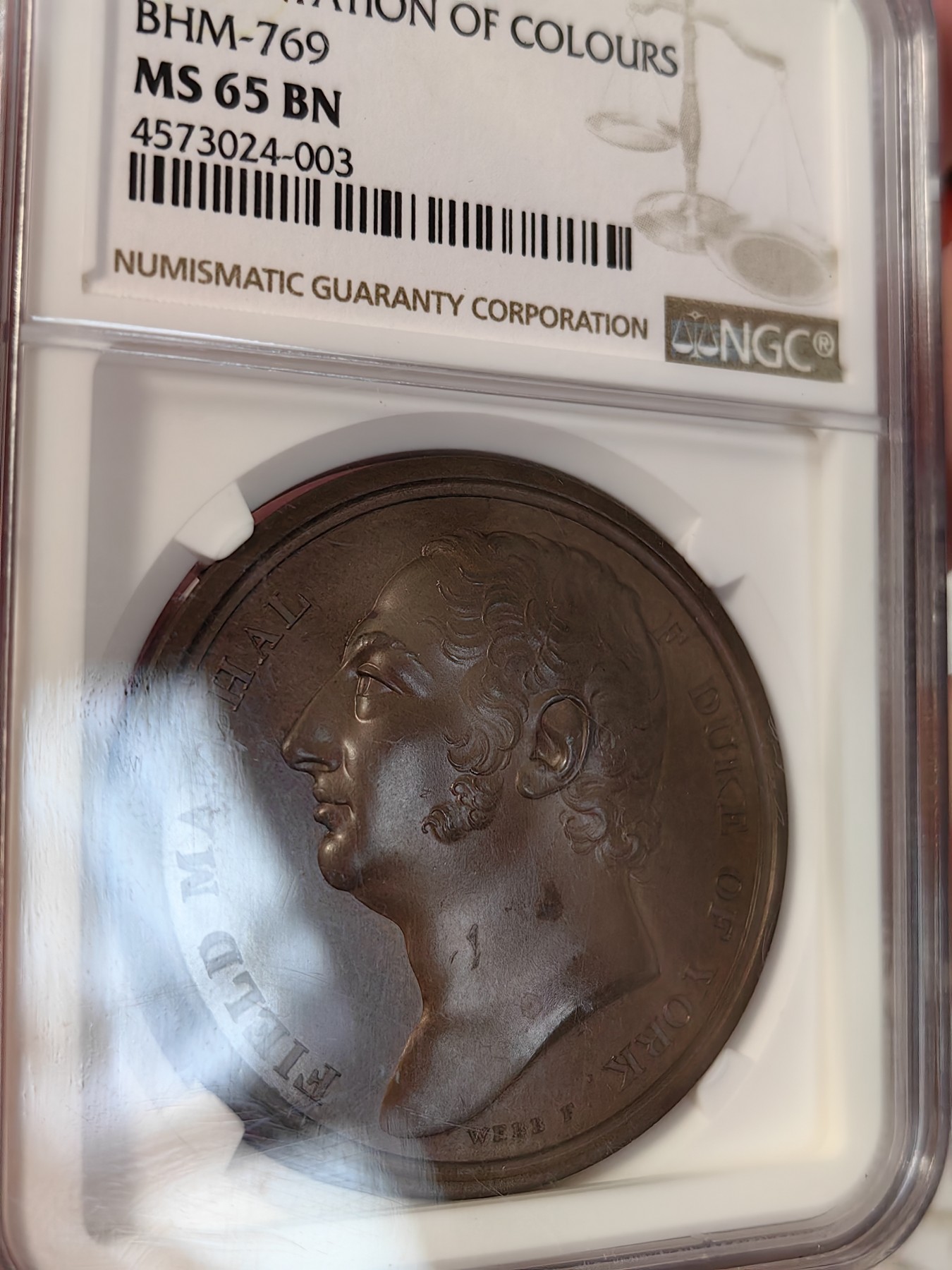 橡树集藏-006场 海纳百川 1813年英国皇室章，乔治三世时期原铸。ngc Ms65，加厚盒。铜色诱人，镜面感十足。背面是女王向皇家近卫军团授予军旗，细节丰富，雕刻精细，超高浮雕。ngc数据库唯一评级，冠军分。军旗上刻字：VIRES ACQUIRT EUNDO。拉丁文，意为“随行聚力”，是古罗马诗人的叙事诗《埃涅阿斯纪》中的一句，意思是“随着传播而越来越有力”。象征着军队听从指挥，雷厉风行。