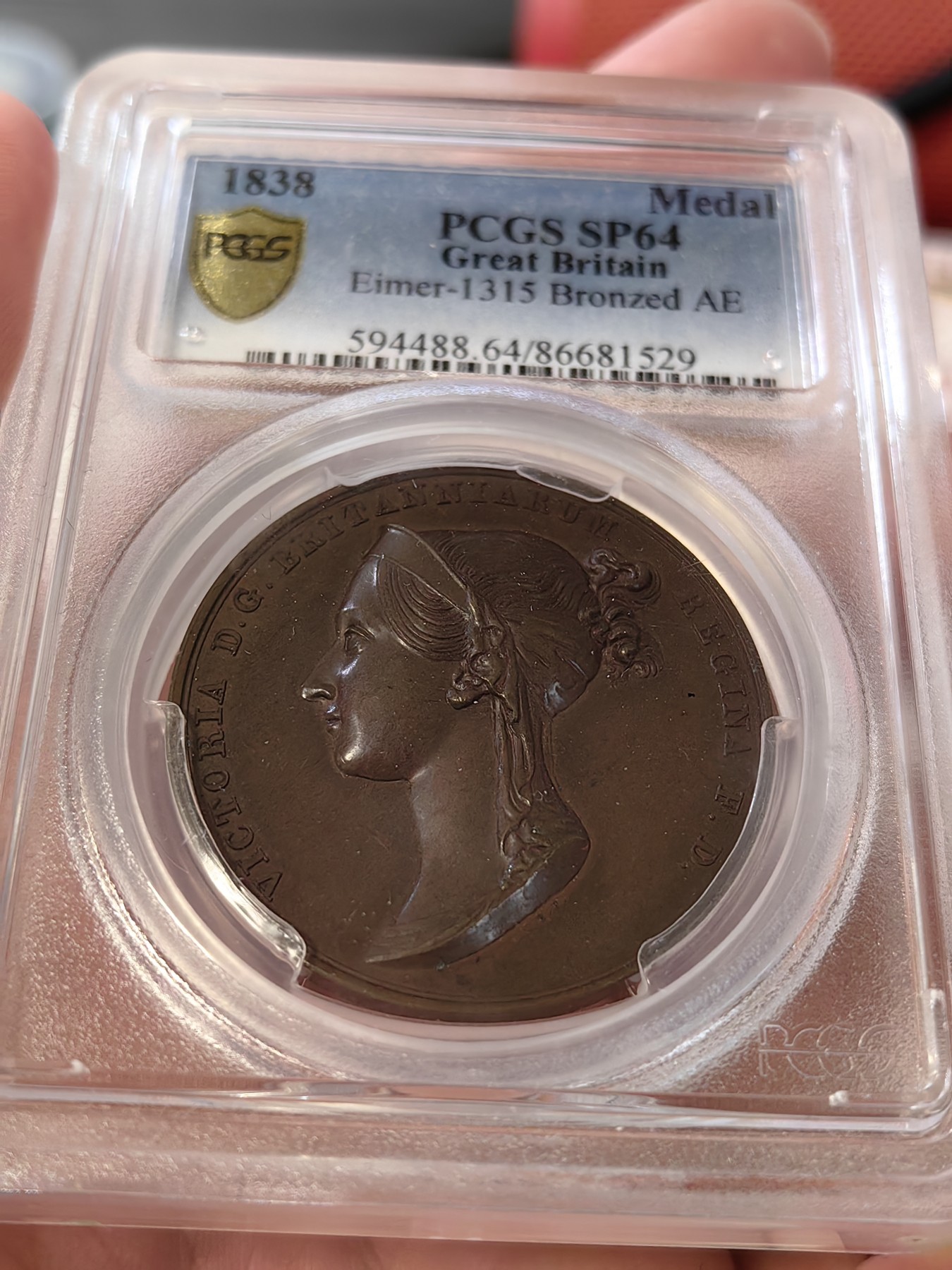 橡树集藏-006场 海纳百川 pcgs-SP64，1838年英国维多利亚女王加冕铜章，皇室官方章。顶级品相，铜色四溢，观感极佳，实物极美。伦敦造币厂，铸造量260枚，直径36mm。超高浮雕，细节令人惊叹，加厚盒。小维，yyds。一个高度充满活力的红棕色标本，表面有大量闪烁的光彩。皮斯特鲁奇操刀，他的代表作：圣乔治屠龙和滑铁卢战役纪念章。天才人物，少年有为。直到今天，女王伊丽莎白二世的主权金币上，还刻着由他设计的圣乔治屠龙形象～