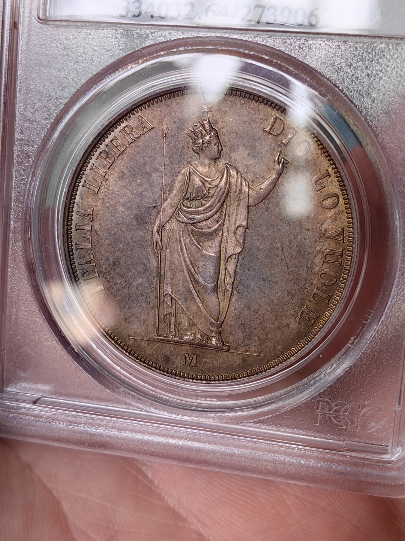 橡树集藏-006场 海纳百川 PCGS MS-64  1848年意大利伦巴第-威尼斯5里拉大银，米兰造币厂。钢灰色的底板呈现出琥珀色和浅洋红色虹彩的痕迹，突出了整个币面。背面有罕见的包浆回声纹，底板几乎没有瑕疵。pc老盒子，品质保证。正面是右手执长矛权杖的加冕自由女神，拉丁铭文:ITALIA LIBERA DIO LO VUOLE，上帝呼唤自由之意大利。女神的左手指向铭文“DIO”,意大利语中上帝的意思，很有深意的经典设计。 