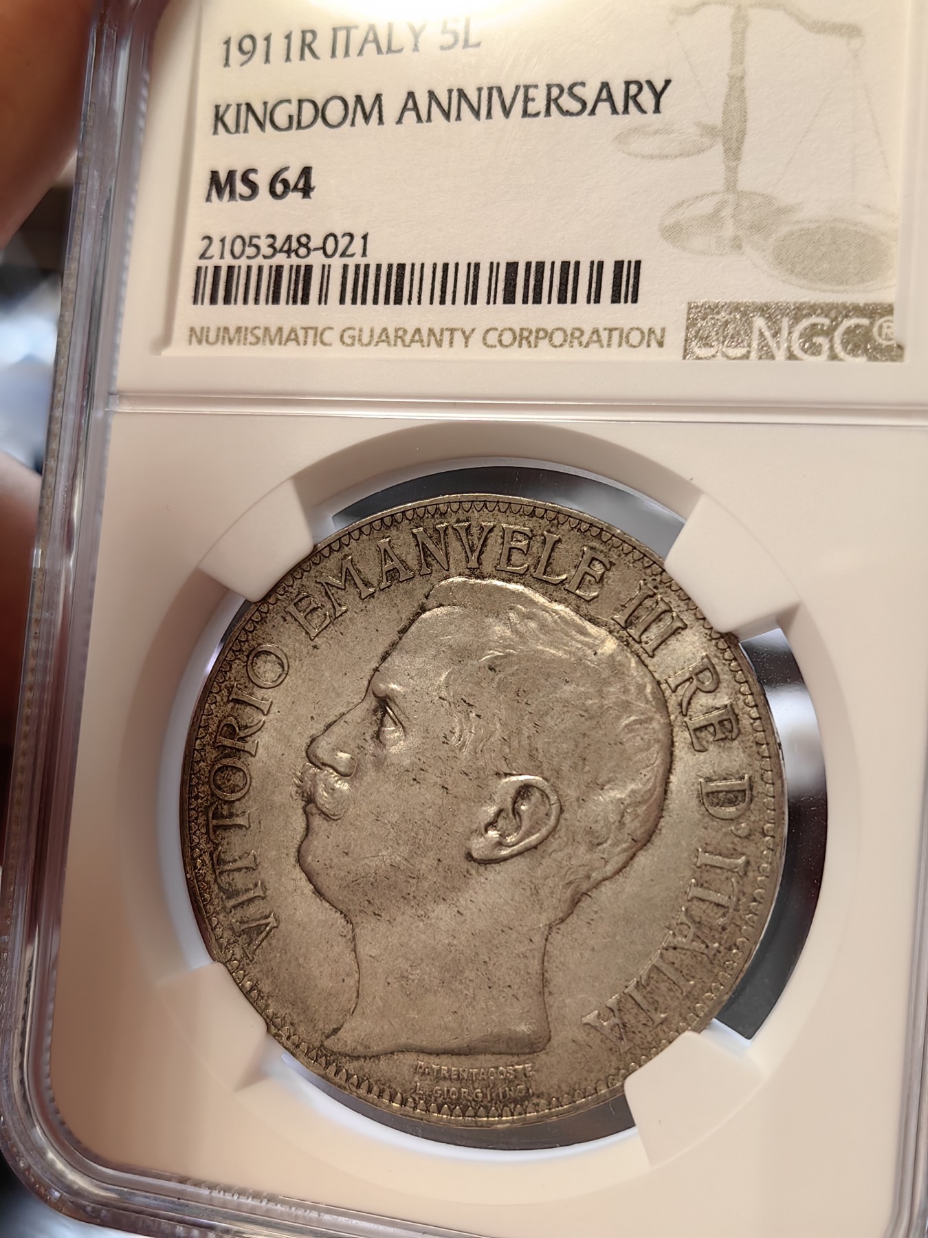 橡树集藏-006场 海纳百川 ngc-ms64 1911年意大利建国5里拉大银币 打制优异 浮雕完好 整体状态相当不错 币圈大托奶  罗马厂内部评选最美设计 正面为埃马努埃莱三世，意大利国王。背面图案为代表古罗马的士兵和代表现代意大利的女神，以及象征工农业繁荣的轮船、犁铧和花环。背面情景指的是古罗马向现代罗马——意大利递送地球，象征治世权力的传承～币的边铭，刻有双环八字结，代表爱的意思，萨伏伊王室常用。
