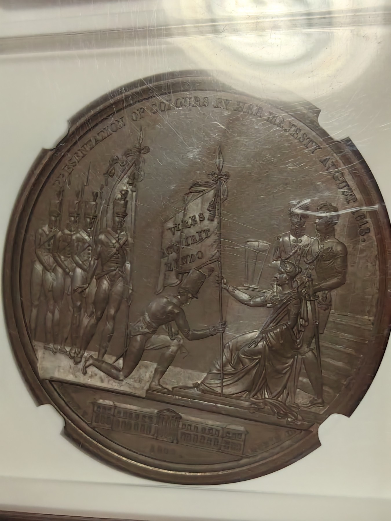 橡树集藏-006场 海纳百川 1813年英国皇室章，乔治三世时期原铸。ngc Ms65，加厚盒。铜色诱人，镜面感十足。背面是女王向皇家近卫军团授予军旗，细节丰富，雕刻精细，超高浮雕。ngc数据库唯一评级，冠军分。军旗上刻字：VIRES ACQUIRT EUNDO。拉丁文，意为“随行聚力”，是古罗马诗人的叙事诗《埃涅阿斯纪》中的一句，意思是“随着传播而越来越有力”。象征着军队听从指挥，雷厉风行。