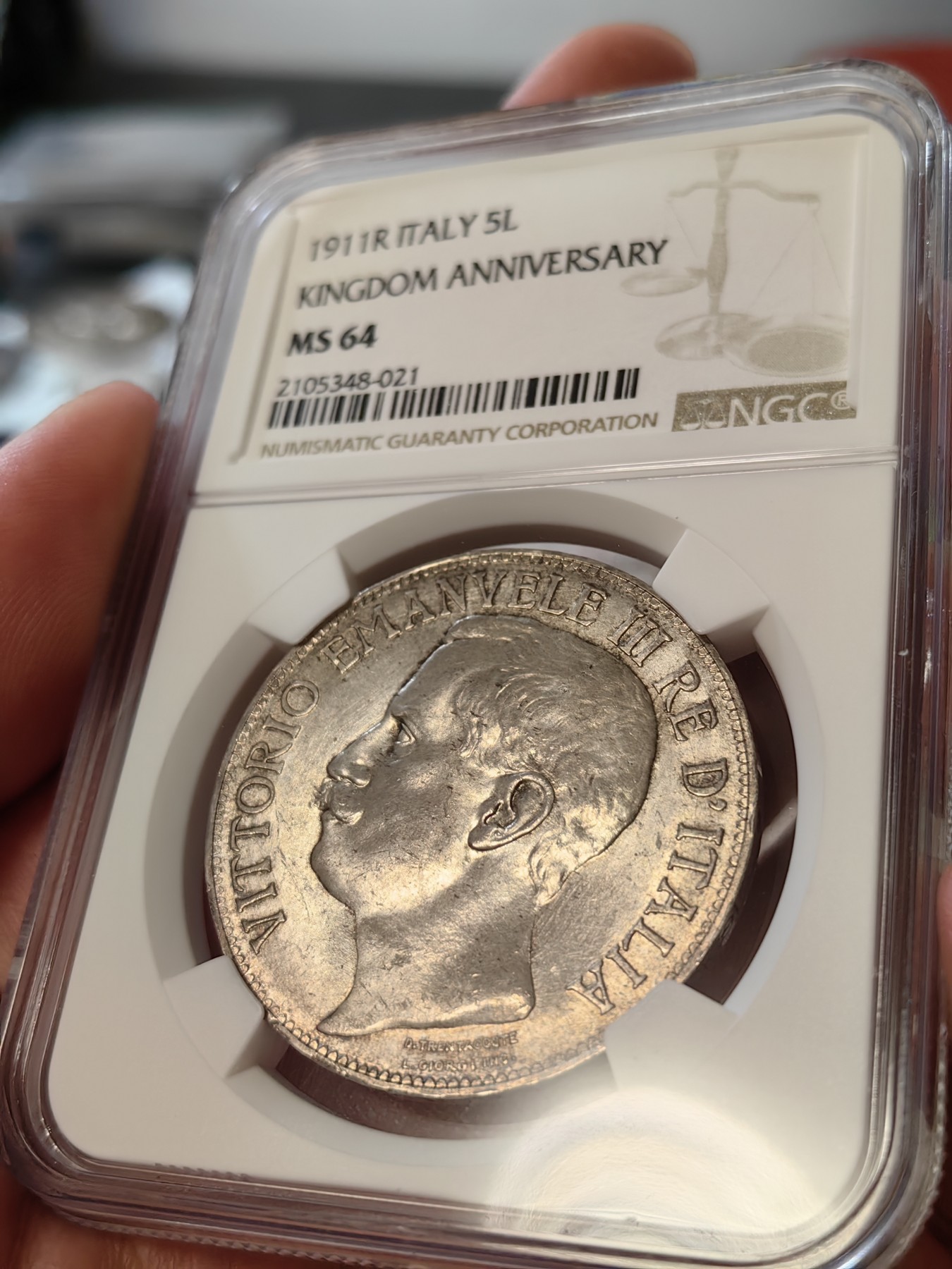 橡树集藏-006场 海纳百川 ngc-ms64 1911年意大利建国5里拉大银币 打制优异 浮雕完好 整体状态相当不错 币圈大托奶  罗马厂内部评选最美设计 正面为埃马努埃莱三世，意大利国王。背面图案为代表古罗马的士兵和代表现代意大利的女神，以及象征工农业繁荣的轮船、犁铧和花环。背面情景指的是古罗马向现代罗马——意大利递送地球，象征治世权力的传承～币的边铭，刻有双环八字结，代表爱的意思，萨伏伊王室常用。