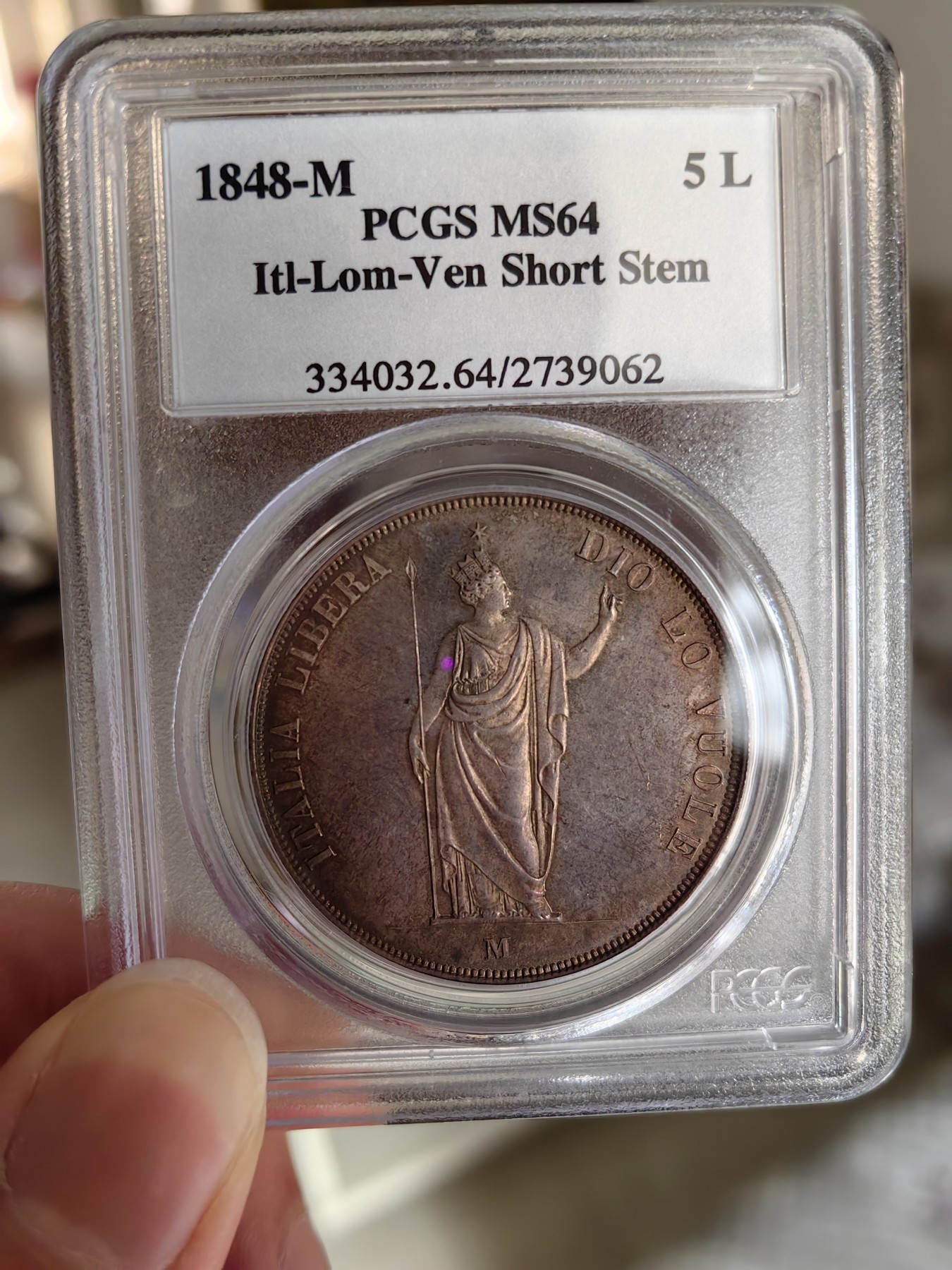 橡树集藏-006场 海纳百川 PCGS MS-64  1848年意大利伦巴第-威尼斯5里拉大银，米兰造币厂。钢灰色的底板呈现出琥珀色和浅洋红色虹彩的痕迹，突出了整个币面。背面有罕见的包浆回声纹，底板几乎没有瑕疵。pc老盒子，品质保证。正面是右手执长矛权杖的加冕自由女神，拉丁铭文:ITALIA LIBERA DIO LO VUOLE，上帝呼唤自由之意大利。女神的左手指向铭文“DIO”,意大利语中上帝的意思，很有深意的经典设计。 