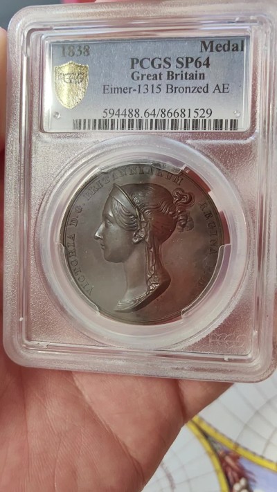 橡树集藏-006场 海纳百川 pcgs-SP64，1838年英国维多利亚女王加冕铜章，皇室官方章。顶级品相，铜色四溢，观感极佳，实物极美。伦敦造币厂，铸造量260枚，直径36mm。超高浮雕，细节令人惊叹，加厚盒。小维，yyds。一个高度充满活力的红棕色标本，表面有大量闪烁的光彩。皮斯特鲁奇操刀，他的代表作：圣乔治屠龙和滑铁卢战役纪念章。天才人物，少年有为。直到今天，女王伊丽莎白二世的主权金币上，还刻着由他设计的圣乔治屠龙形象～
