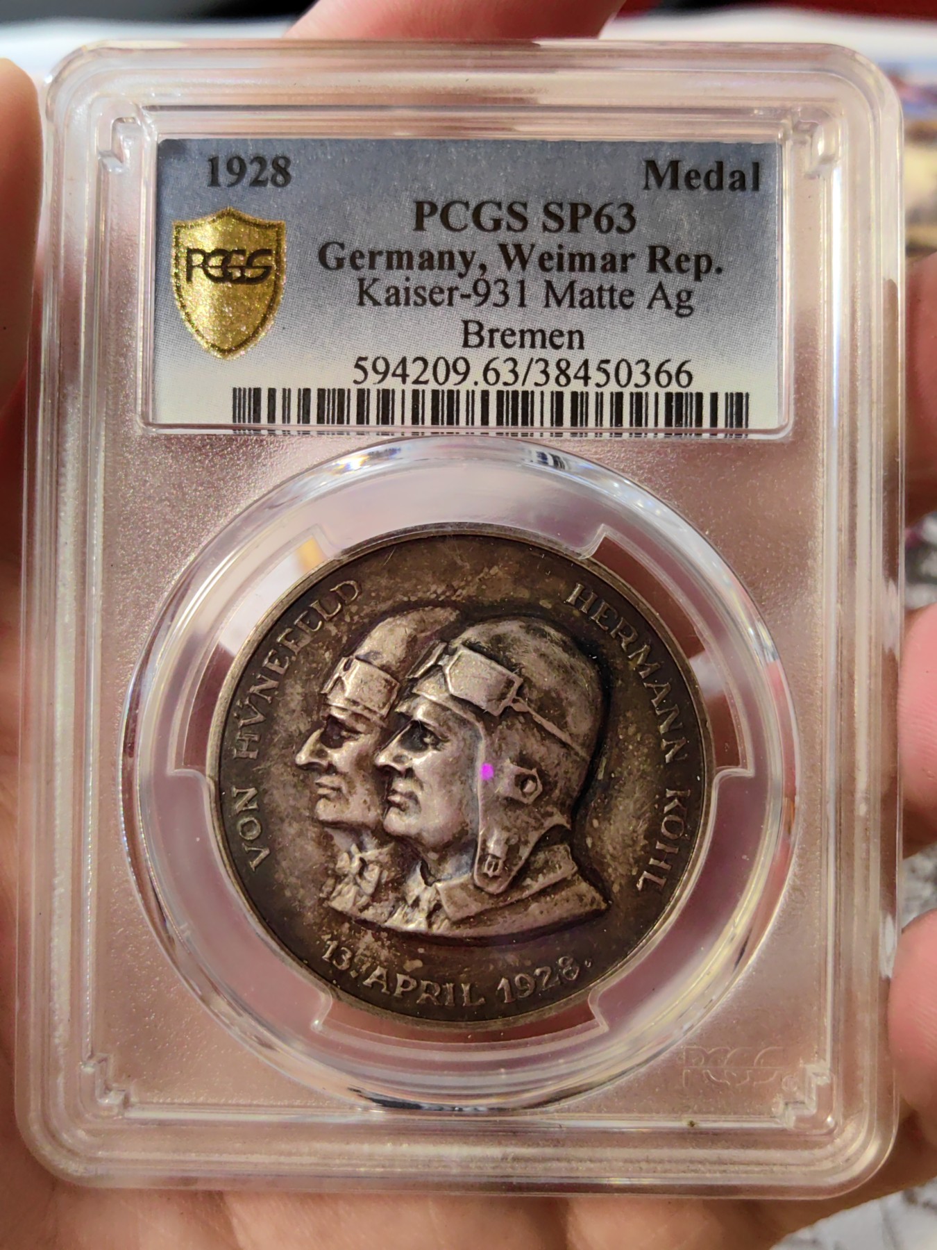 橡树集藏-006场 海纳百川 1928年德国银章，pcgs SP63。纪念不莱梅号飞机飞越大西洋。1928年4月13日，两名德国飞行员驾驶飞机在美国费城着陆，这是人类首次驾驶飞机从大西洋东岸飞到西岸。这两名飞行员在费城受到了盛大欢迎，德国人也以他们为傲，发行 多枚以此事件为主题的纪念章。 双面浓郁包浆，五彩，超高浮雕，实物极美。 人物刻画精细，背面的不莱梅号穿过云雾，飞翔在大西洋上空，海面波光粼粼，惟妙惟肖。