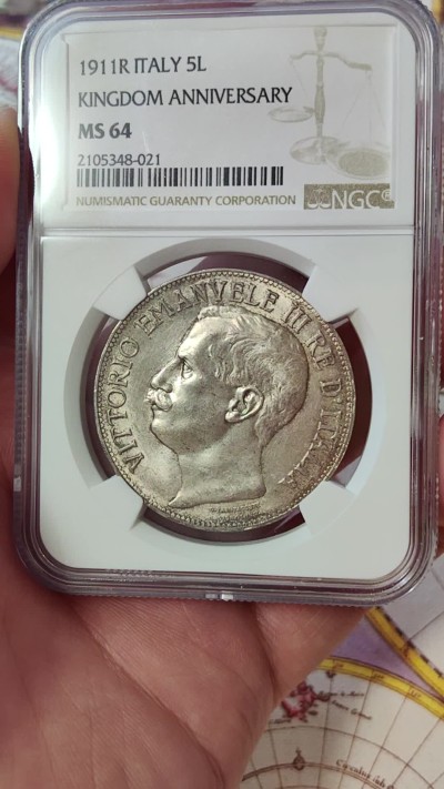 橡树集藏-006场 海纳百川 ngc-ms64 1911年意大利建国5里拉大银币 打制优异 浮雕完好 整体状态相当不错 币圈大托奶  罗马厂内部评选最美设计 正面为埃马努埃莱三世，意大利国王。背面图案为代表古罗马的士兵和代表现代意大利的女神，以及象征工农业繁荣的轮船、犁铧和花环。背面情景指的是古罗马向现代罗马——意大利递送地球，象征治世权力的传承～币的边铭，刻有双环八字结，代表爱的意思，萨伏伊王室常用。