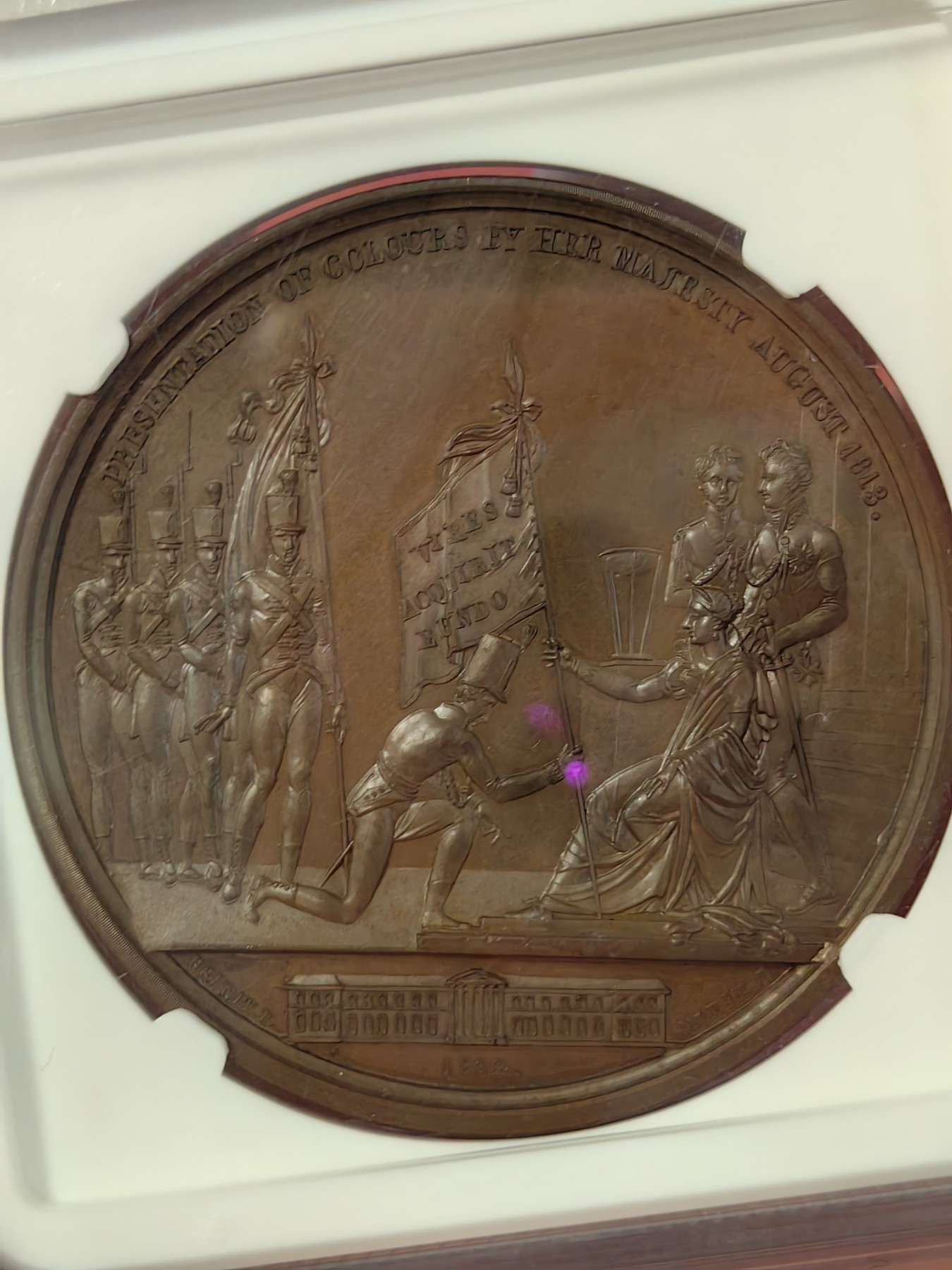 橡树集藏-006场 海纳百川 1813年英国皇室章，乔治三世时期原铸。ngc Ms65，加厚盒。铜色诱人，镜面感十足。背面是女王向皇家近卫军团授予军旗，细节丰富，雕刻精细，超高浮雕。ngc数据库唯一评级，冠军分。军旗上刻字：VIRES ACQUIRT EUNDO。拉丁文，意为“随行聚力”，是古罗马诗人的叙事诗《埃涅阿斯纪》中的一句，意思是“随着传播而越来越有力”。象征着军队听从指挥，雷厉风行。