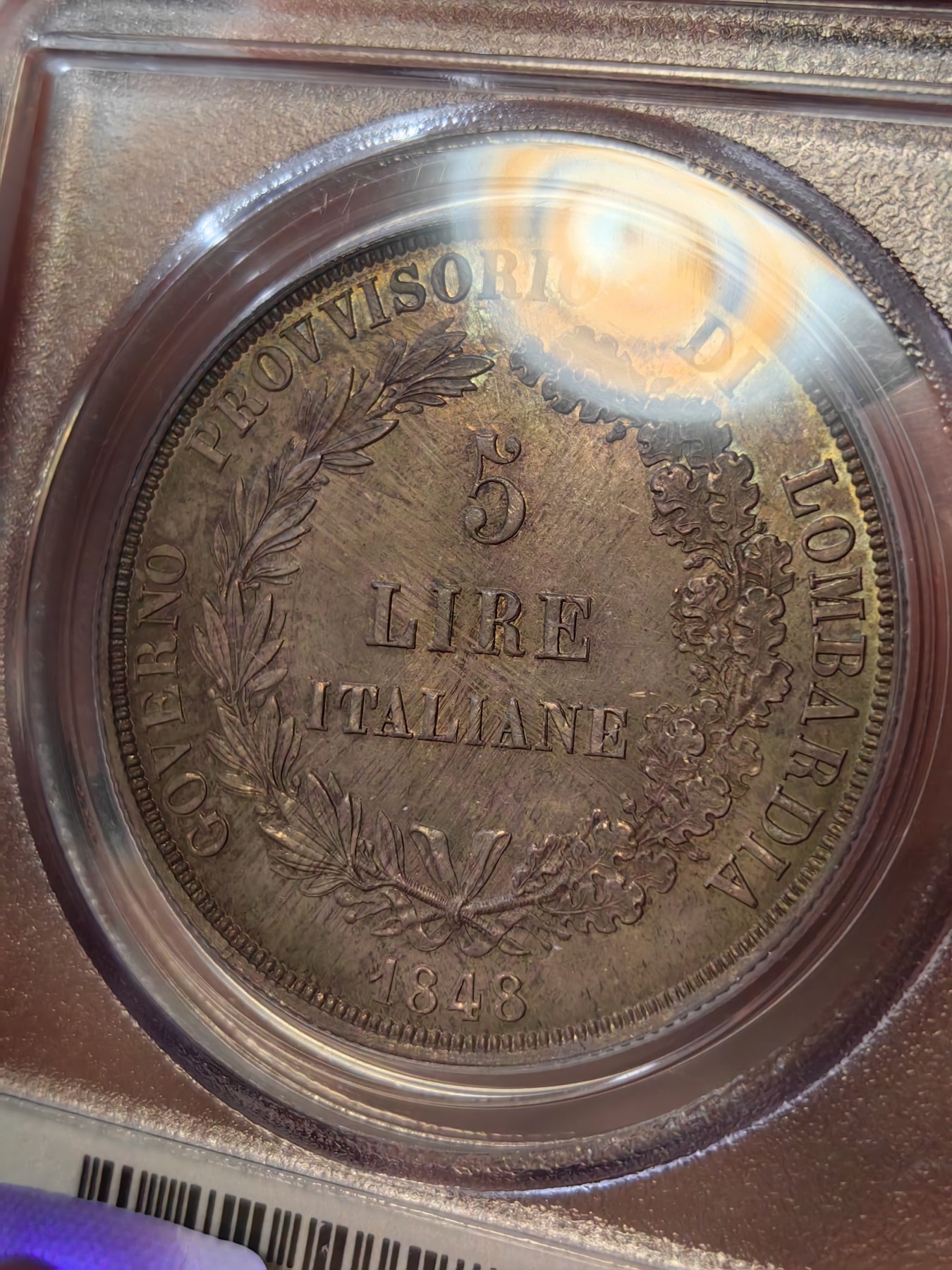 橡树集藏-006场 海纳百川 PCGS MS-64  1848年意大利伦巴第-威尼斯5里拉大银，米兰造币厂。钢灰色的底板呈现出琥珀色和浅洋红色虹彩的痕迹，突出了整个币面。背面有罕见的包浆回声纹，底板几乎没有瑕疵。pc老盒子，品质保证。正面是右手执长矛权杖的加冕自由女神，拉丁铭文:ITALIA LIBERA DIO LO VUOLE，上帝呼唤自由之意大利。女神的左手指向铭文“DIO”,意大利语中上帝的意思，很有深意的经典设计。 