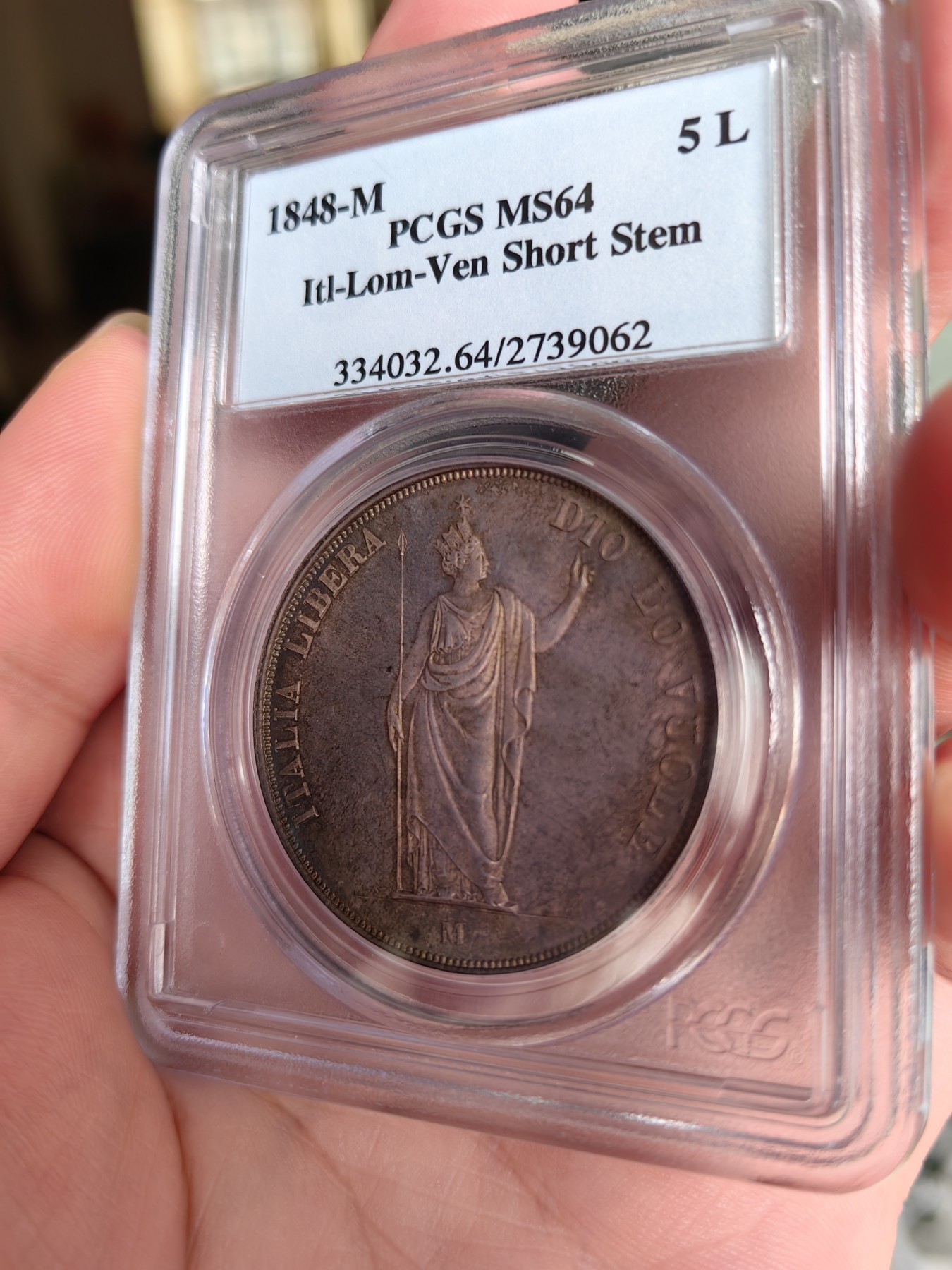 橡树集藏-006场 海纳百川 PCGS MS-64  1848年意大利伦巴第-威尼斯5里拉大银，米兰造币厂。钢灰色的底板呈现出琥珀色和浅洋红色虹彩的痕迹，突出了整个币面。背面有罕见的包浆回声纹，底板几乎没有瑕疵。pc老盒子，品质保证。正面是右手执长矛权杖的加冕自由女神，拉丁铭文:ITALIA LIBERA DIO LO VUOLE，上帝呼唤自由之意大利。女神的左手指向铭文“DIO”,意大利语中上帝的意思，很有深意的经典设计。 