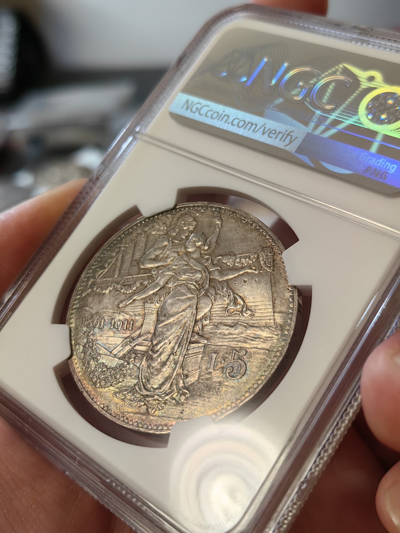 橡树集藏-006场 海纳百川 ngc-ms64 1911年意大利建国5里拉大银币 打制优异 浮雕完好 整体状态相当不错 币圈大托奶  罗马厂内部评选最美设计 正面为埃马努埃莱三世，意大利国王。背面图案为代表古罗马的士兵和代表现代意大利的女神，以及象征工农业繁荣的轮船、犁铧和花环。背面情景指的是古罗马向现代罗马——意大利递送地球，象征治世权力的传承～币的边铭，刻有双环八字结，代表爱的意思，萨伏伊王室常用。