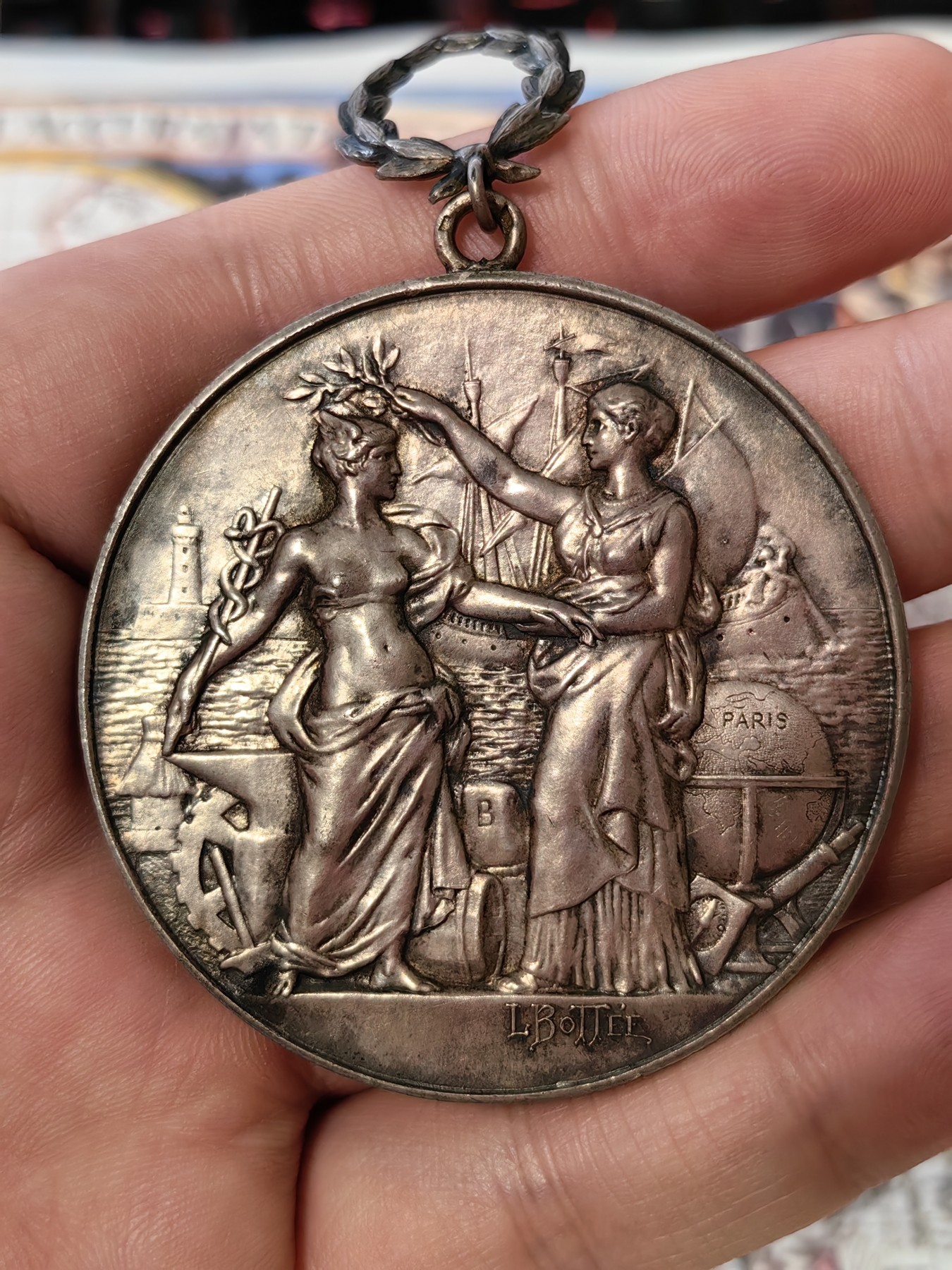 橡树集藏-006场 海纳百川 法国商业地理学会银奖章，1899 年。GEM 未流通。51毫米，58.92 克。作者：L.Botte。1899 年发行并赠送给卡米尔-莱昂-伊波利特·胡格南。正面：地理女神站在左侧，将月桂花环放在商业女神上，手持双杖；背景是商业和工业的标志，例如地球仪、敦、齿轮、铁砧、灯塔和船。完美出厂品相，高浮雕细节极佳，女神和天使柔美动人。