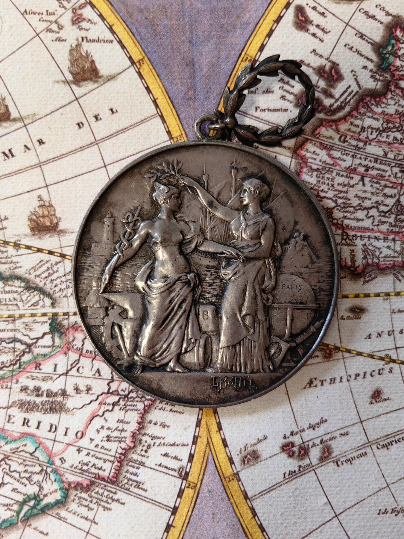 橡树集藏-006场 海纳百川 法国商业地理学会银奖章，1899 年。GEM 未流通。51毫米，58.92 克。作者：L.Botte。1899 年发行并赠送给卡米尔-莱昂-伊波利特·胡格南。正面：地理女神站在左侧，将月桂花环放在商业女神上，手持双杖；背景是商业和工业的标志，例如地球仪、敦、齿轮、铁砧、灯塔和船。完美出厂品相，高浮雕细节极佳，女神和天使柔美动人。