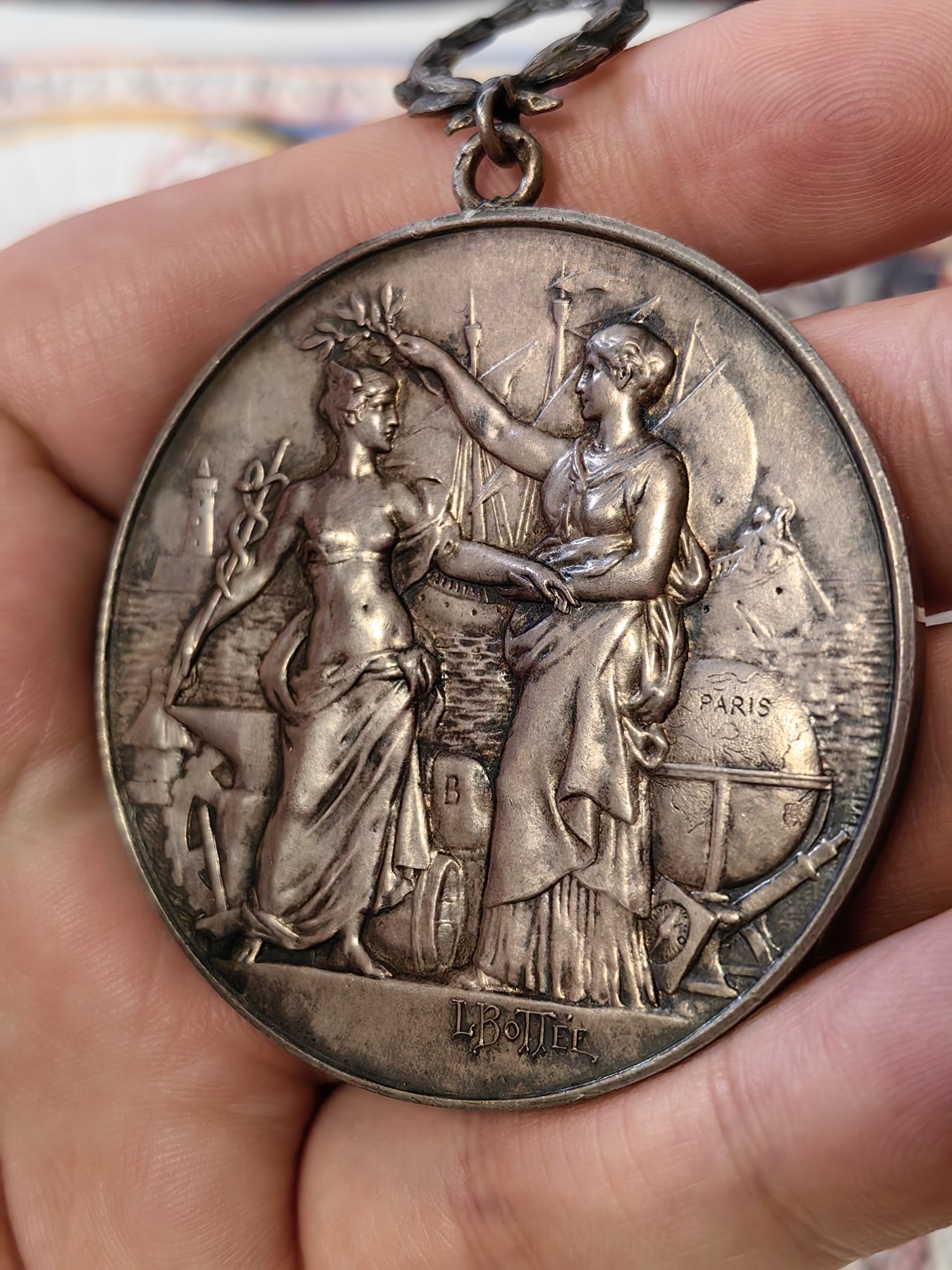 橡树集藏-006场 海纳百川 法国商业地理学会银奖章，1899 年。GEM 未流通。51毫米，58.92 克。作者：L.Botte。1899 年发行并赠送给卡米尔-莱昂-伊波利特·胡格南。正面：地理女神站在左侧，将月桂花环放在商业女神上，手持双杖；背景是商业和工业的标志，例如地球仪、敦、齿轮、铁砧、灯塔和船。完美出厂品相，高浮雕细节极佳，女神和天使柔美动人。