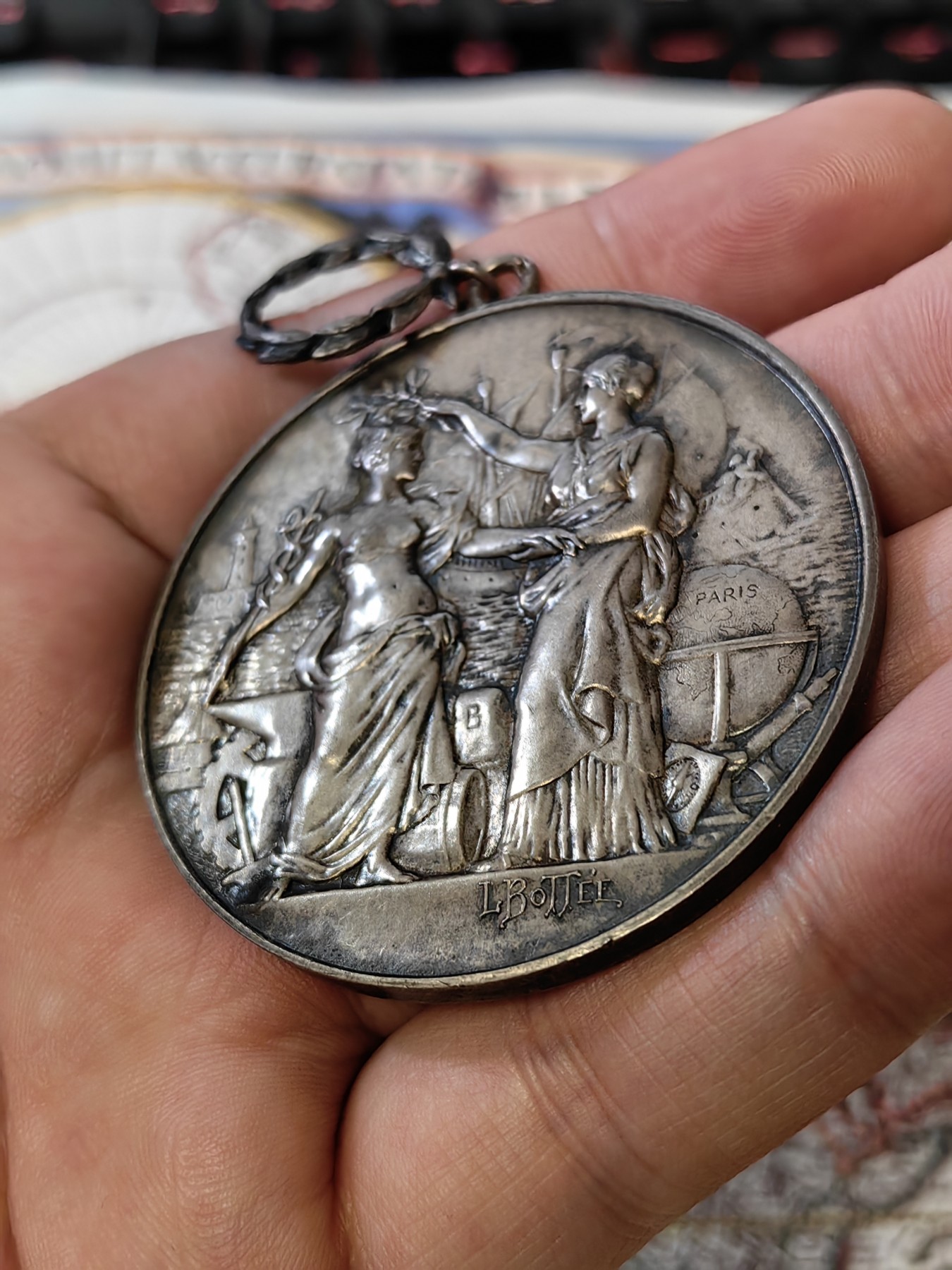 橡树集藏-006场 海纳百川 法国商业地理学会银奖章，1899 年。GEM 未流通。51毫米，58.92 克。作者：L.Botte。1899 年发行并赠送给卡米尔-莱昂-伊波利特·胡格南。正面：地理女神站在左侧，将月桂花环放在商业女神上，手持双杖；背景是商业和工业的标志，例如地球仪、敦、齿轮、铁砧、灯塔和船。完美出厂品相，高浮雕细节极佳，女神和天使柔美动人。