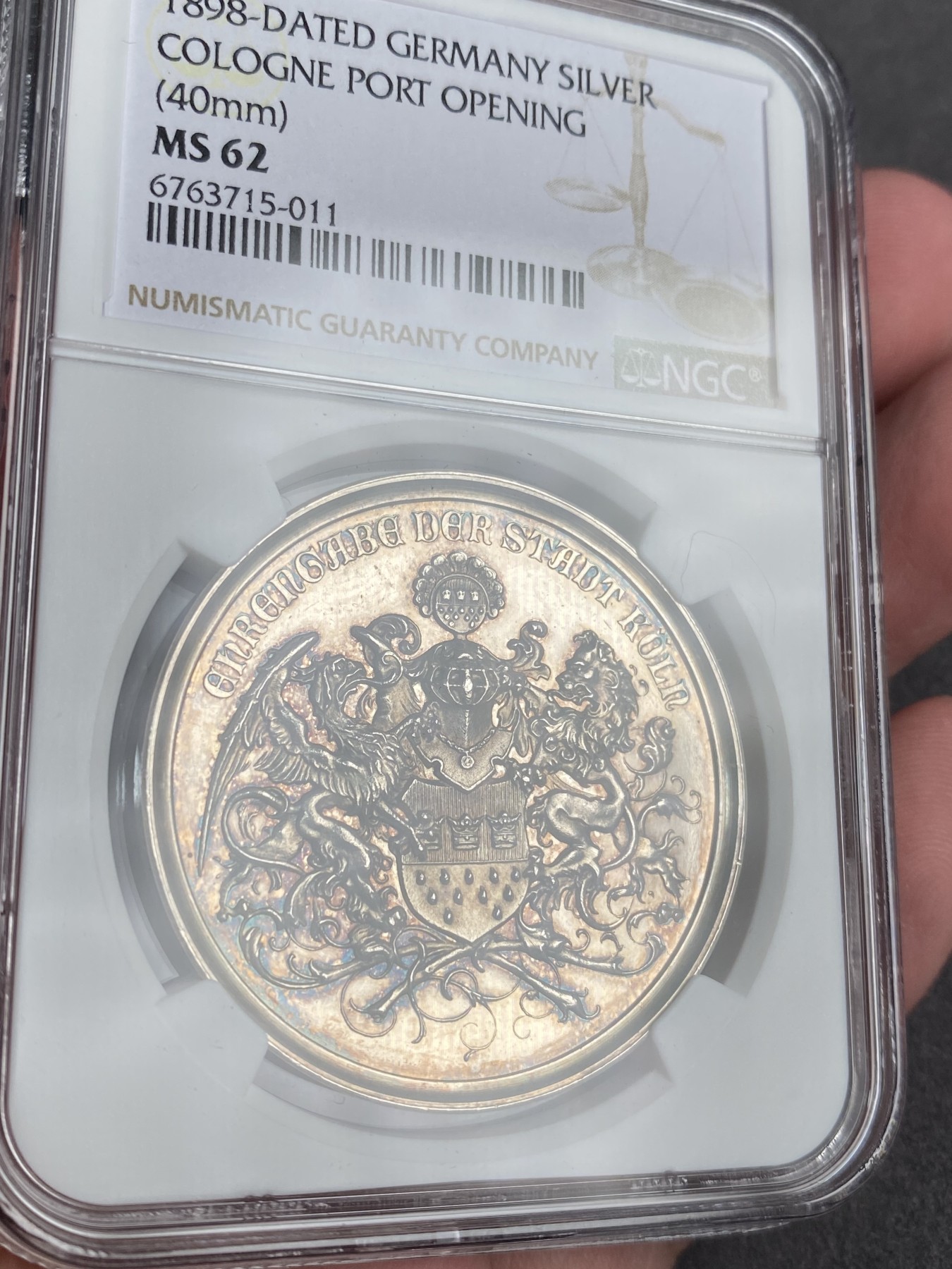 万国钱币拍卖第013期（视频直播专场） NGC MS62 1898年德国圣城科隆新港口开放典礼纪念大银章 欧洲彩，科隆城市纹章在币章中出现不多，此枚将圣城的狮鹫+雄狮盾徽完美的具象化了，非常难得和少见，40MM 22G