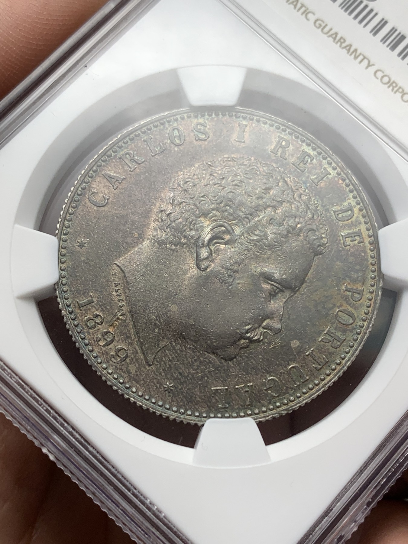 《竞宝斋》第188场-周日，周一 2场 (全场包邮) NGC MS62 葡萄牙1899年卡洛斯一世头像1000瑞斯银币，国币流行黑浆彩，一流老味道。状态极其出色