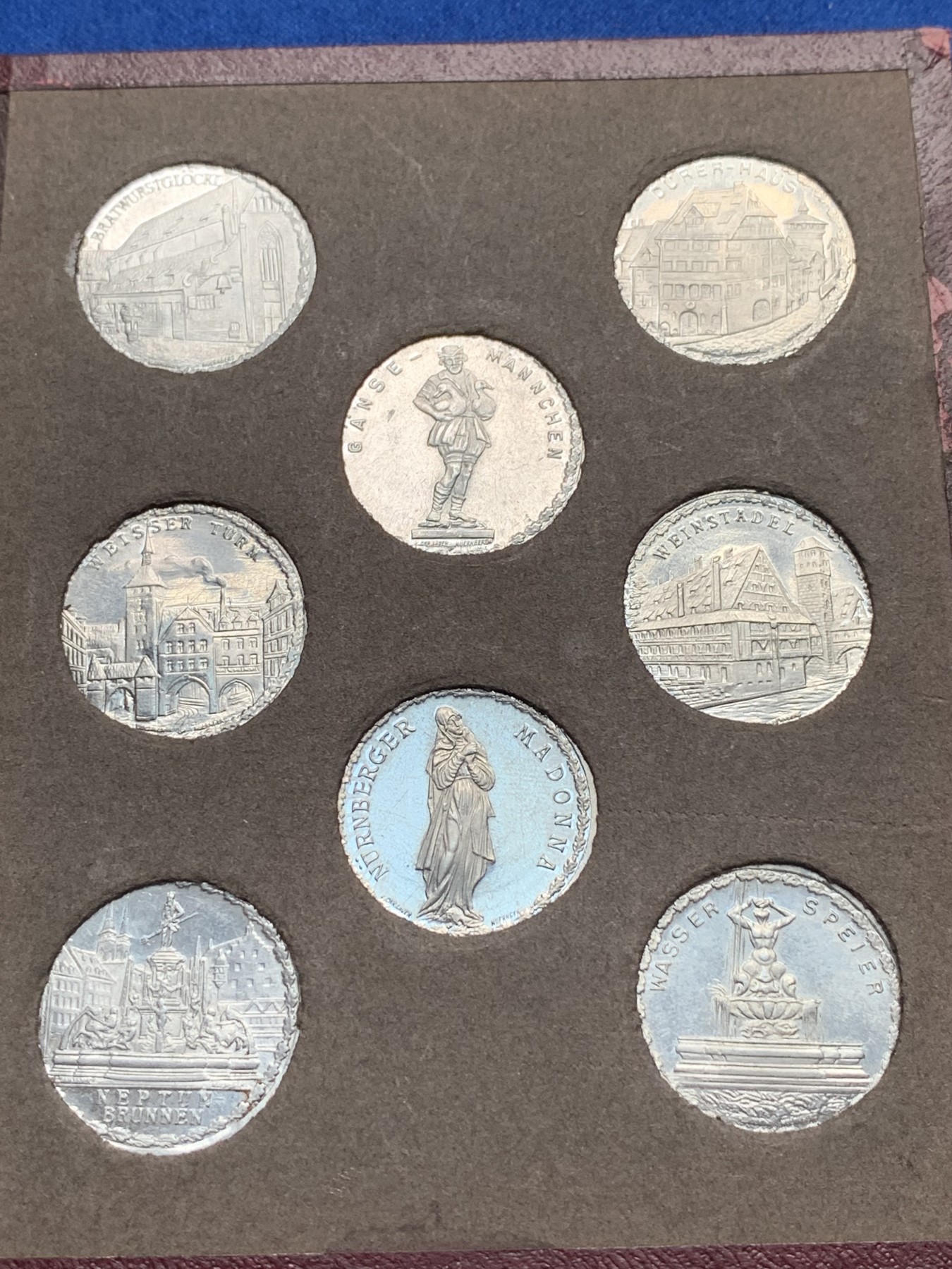 《竞宝斋》第190场-周日，周一 2场 (全场包邮) 德国紧急状态纽伦堡电车代用币大全套1921年德国纽伦堡有轨电车代用币大全套，45枚八角20芬妮铝币，城市景观，历史人物，翻页原皮盒装，完美品相，非常少见，市场上同品相单枚评级币价值不菲。