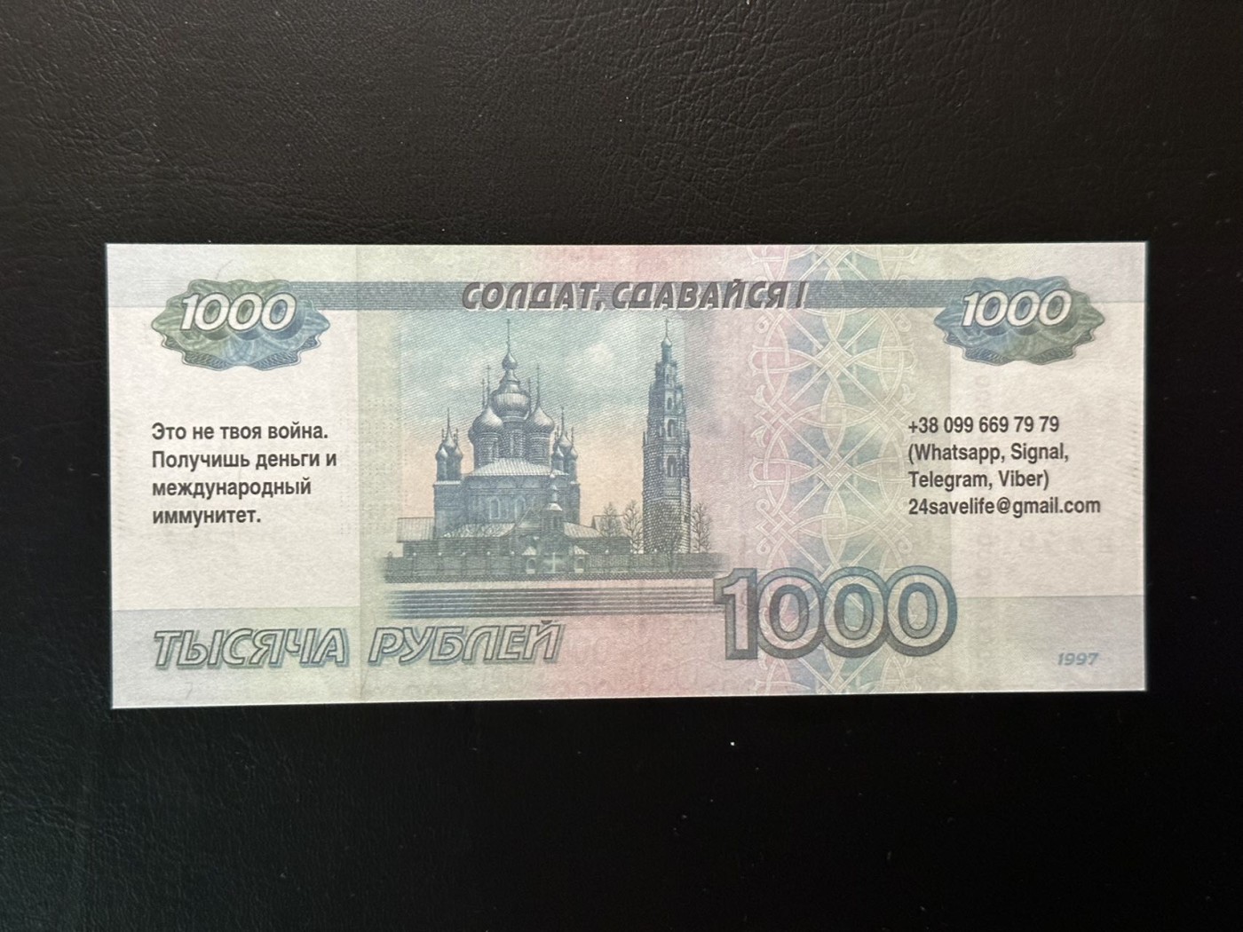 八月最后一场，第十五期大拍 （S2）俄乌战争的一手史料，乌军在进攻阶段对俄军投放的劝降券，上面印有（士兵，放弃吧）（这场战争不属于你，你会得到钱和国际豁免权）以及联系方式。  红圈处翻译错误，应为（俄罗斯银行券，伪造将被起诉）