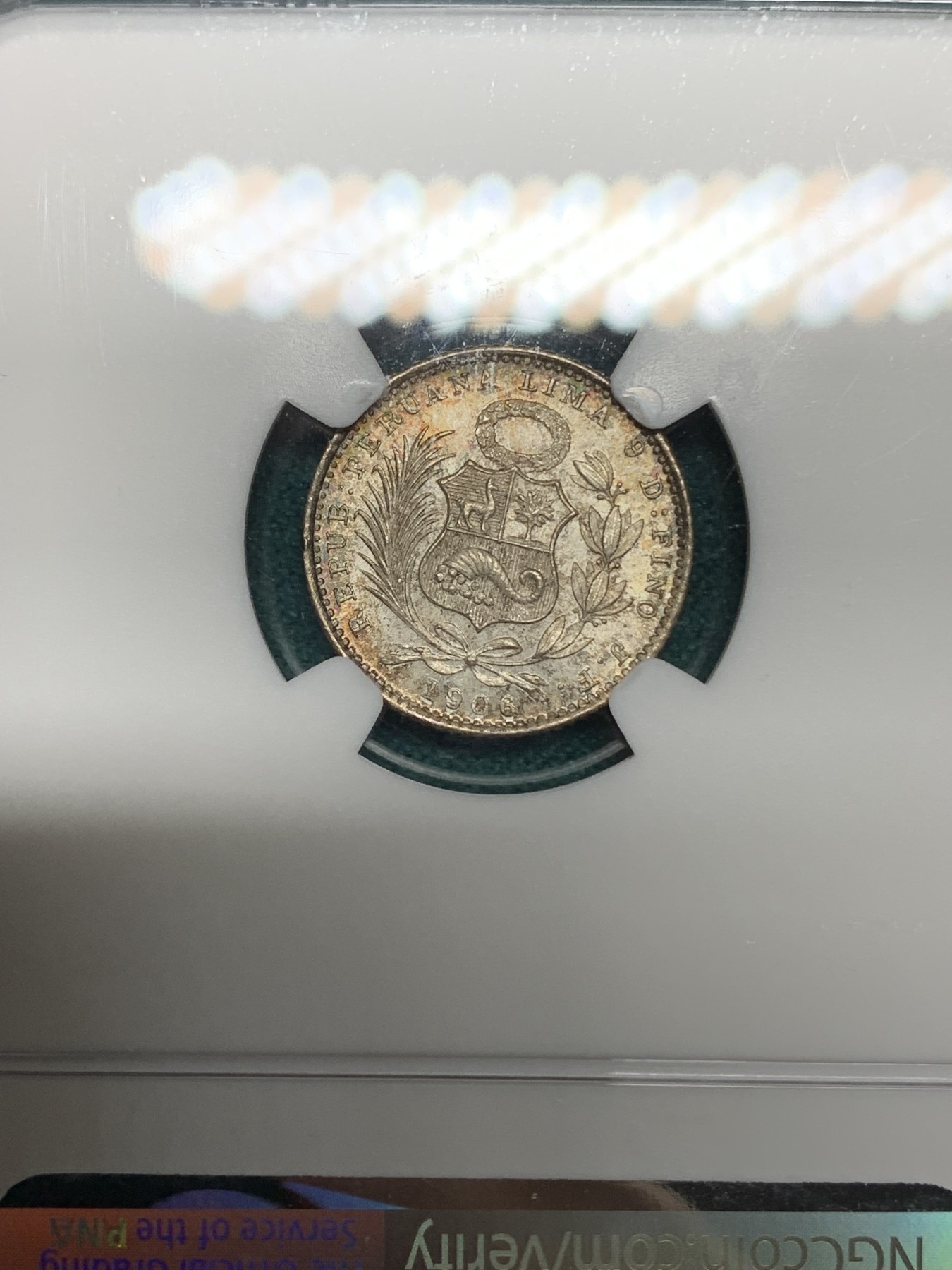 《竞宝斋》第192场-周日，周一 2场 (全场包邮) NGC-MS65 1906年秘鲁1第纳尔坐人女神银币，少见面值，彩浆顶级状态。国内常见为1/2第纳尔，1第纳尔首见。65收藏级高分。